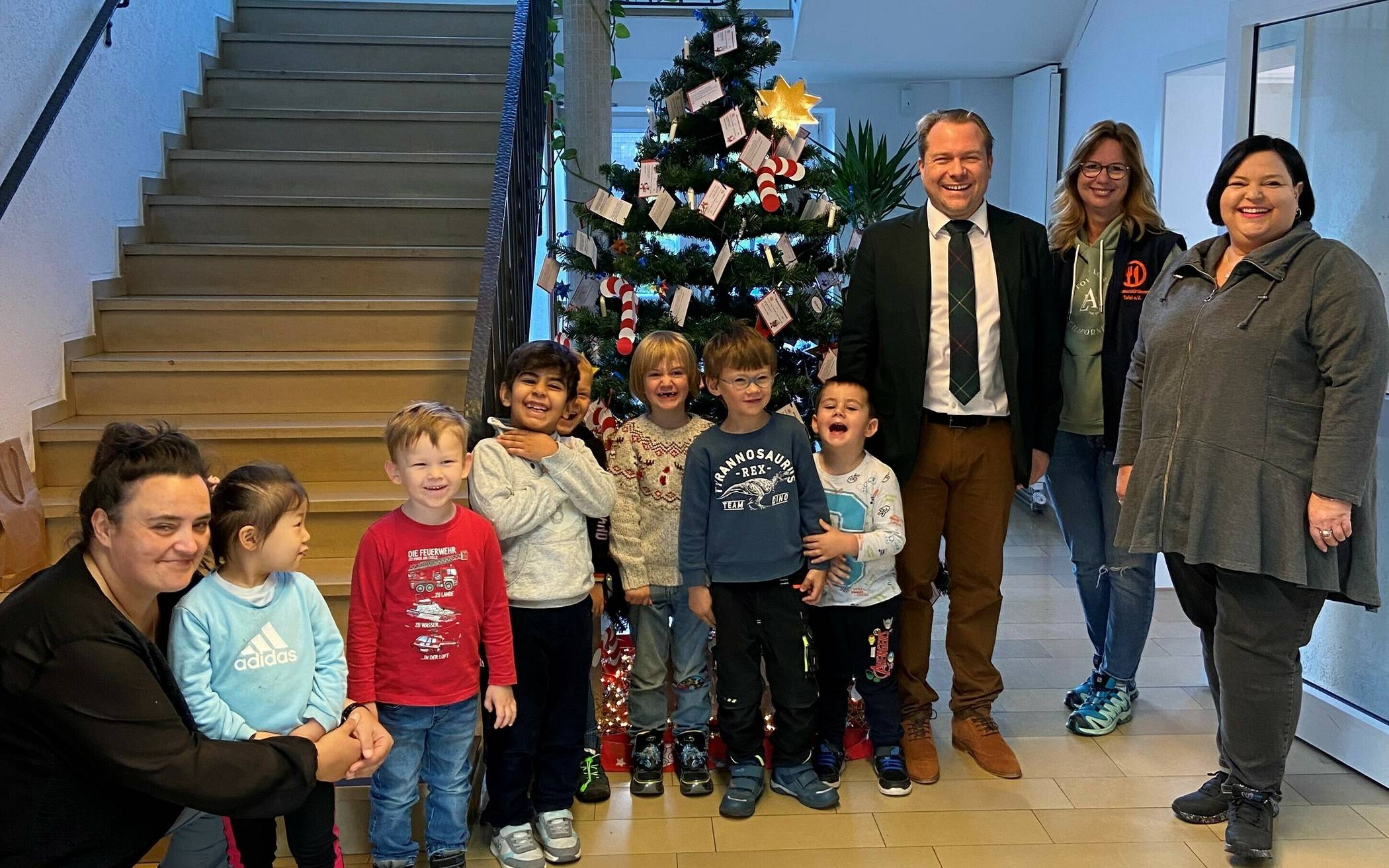  Bürgermeister Mertens und Kinder der KiTa „Sonnenhaus“ schmücken den Weihnachtswunschbaum der Tafel.  