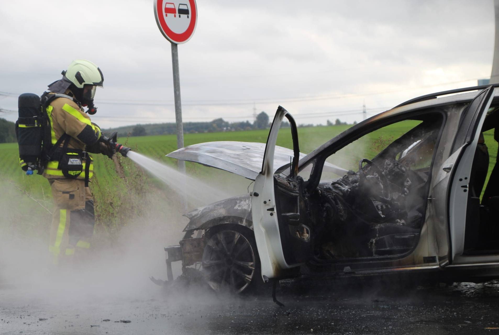  Die Feuerwehr löscht einen Fahrzeugbrand auf der B 59. 