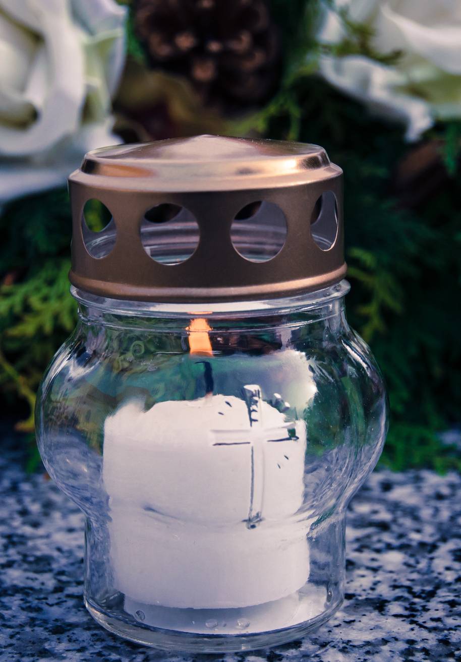  burning candle on grave with wreath 