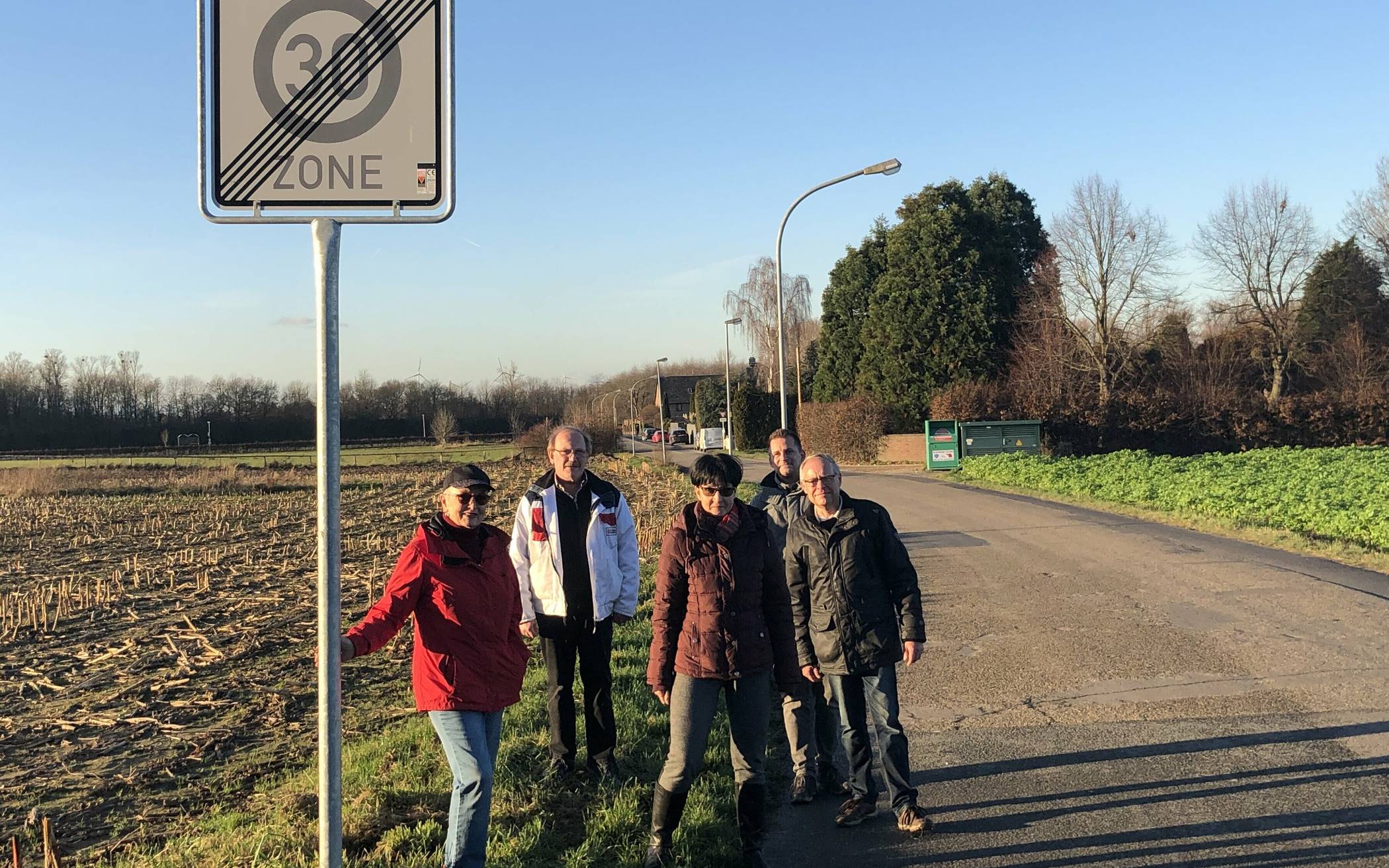  Da, wo der Bürgersteig aufhört, endet auch die 30er-Zone. Danach dürfen die Autofahrer wieder 50 fahren, sollen aber auf spielende Kinder achten (Schilder links oben). Das funktioniert aber nicht, wissen die Anlieger Birgit Vesper, Ulrich und Monika Effertz, Jürgen Heinen und Ulrich Stangier (von links). Der Grünsteifen, auf dem sie demonstrativ stehen, würde für einen sicheren Fußweg für die Schüler, aber auch für die KiTa-Kinder und die Reitstall-Besucher ausreichen. Wenn er denn umgebaut würde. Jetzt müssen die Kids direkt auf der Straße gehen... 
  