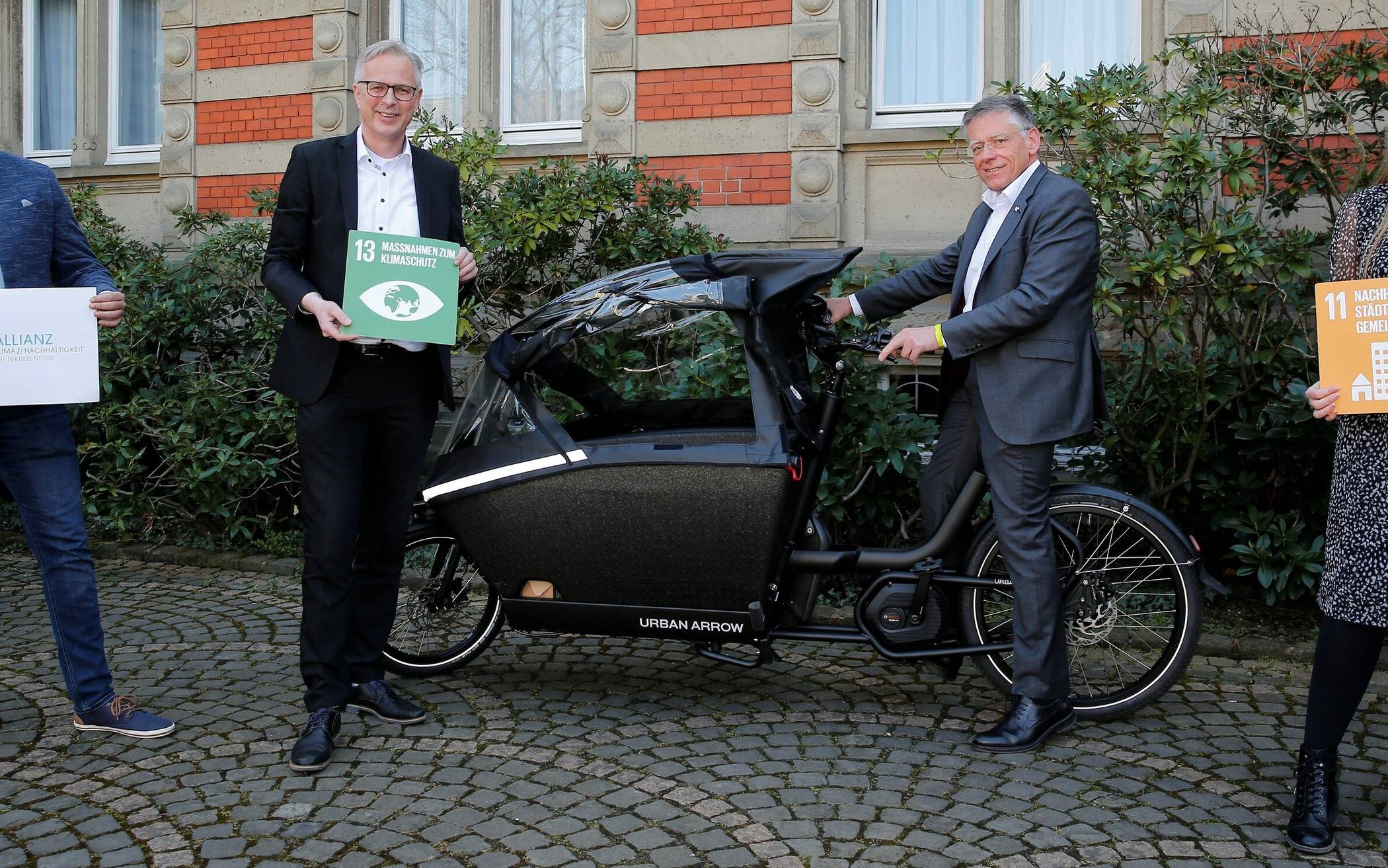  Vor dem Kreisständehaus in Grevenbroich präsentieren Landrat Hans-Jürgen Petrauschke (rechts), Kreisdirektor Dirk Brügge (Zweiter von links), Thiago de Carvalho Zakrzewski und Samira Smentkowski das neue e-Lastenrad beim Kreis. 