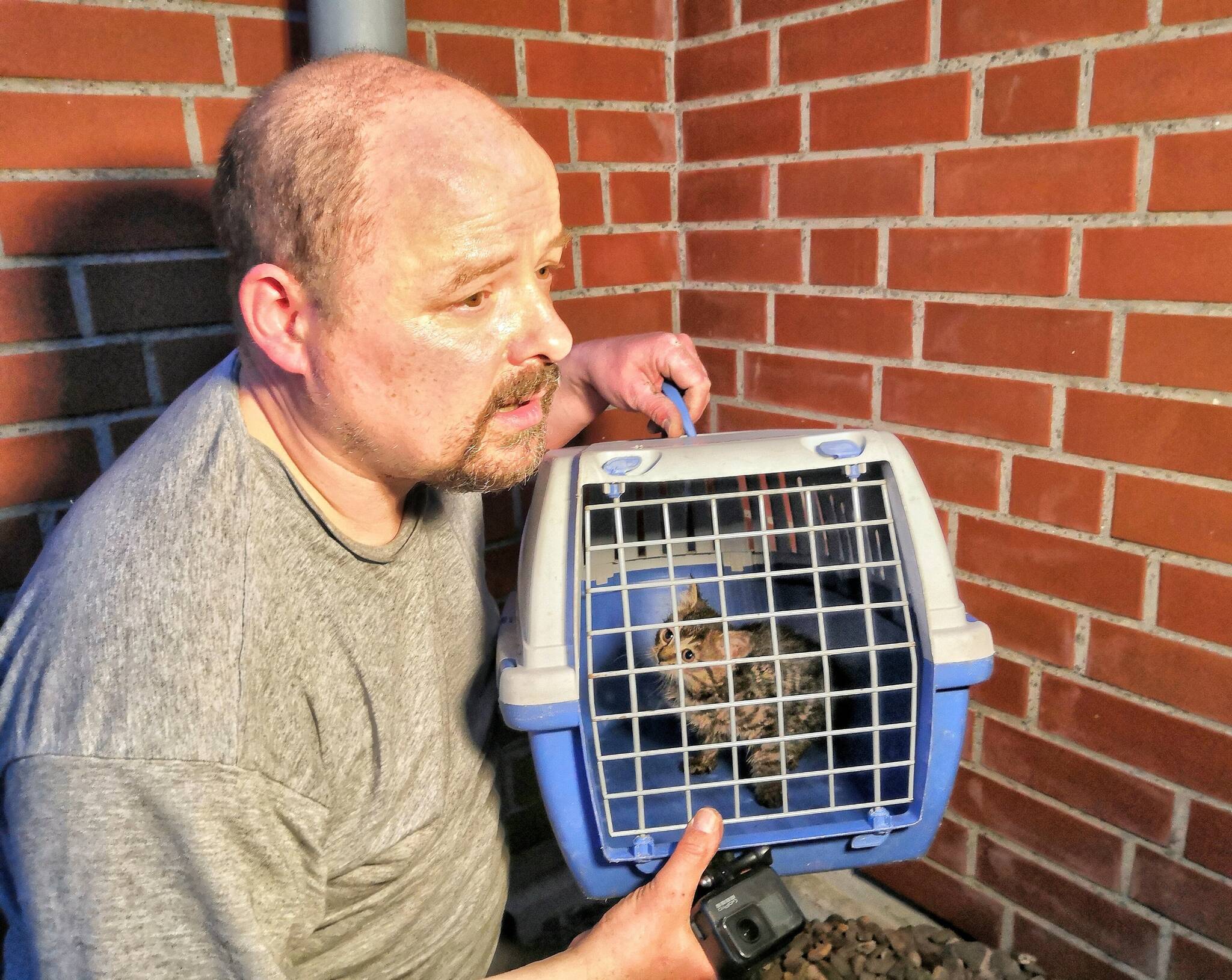  Stefan Bröckling vom ehrenamtlichen Tiernotruf Düsseldorf hält das Tierkind in einer Tiertransportkiste der Feuerwehr. 