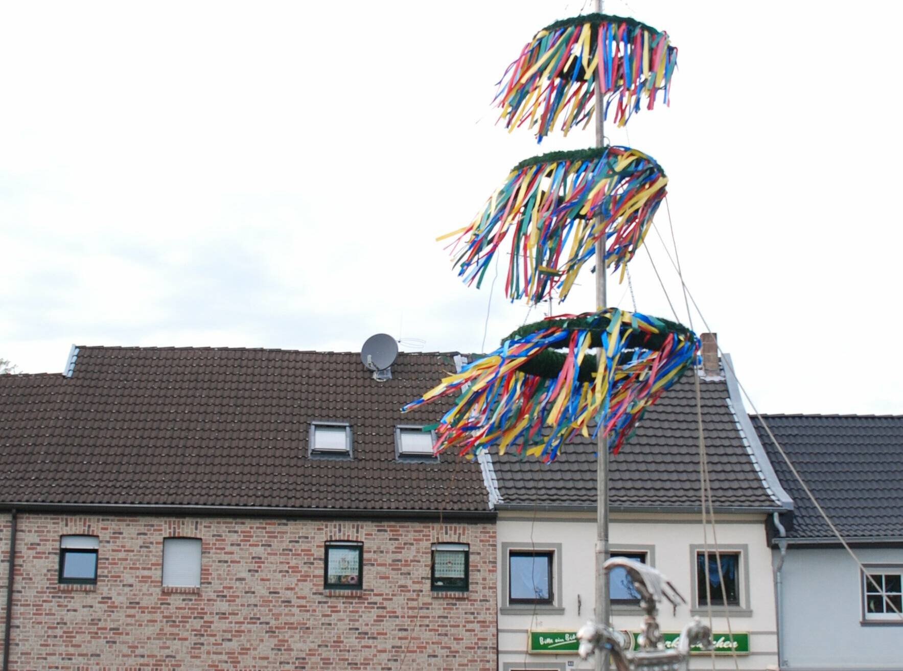 Der Maibaum wird von Kindern geschmückt.