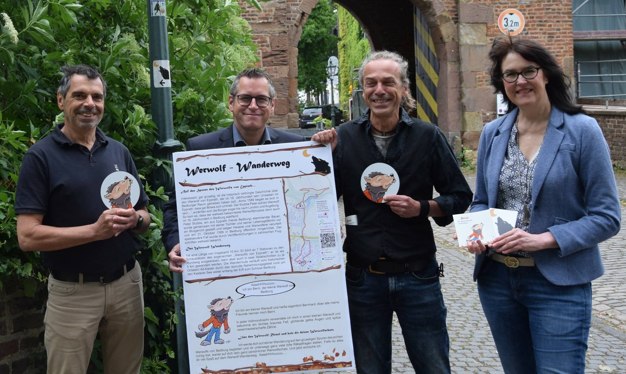  Im Bild von links nach rechts: Robert Heinen (Vize-Fachdienstleiter Öffentlichkeitsarbeit, Stadtmarketing, Tourismus), Sascha Solbach (Bürgermeister), Jan Hillen (Illustrator) und Doris Steinbach (Tourismusbeauftragte) am Einstieg zum Werwolf-Wanderweg in Alt Kaster. 