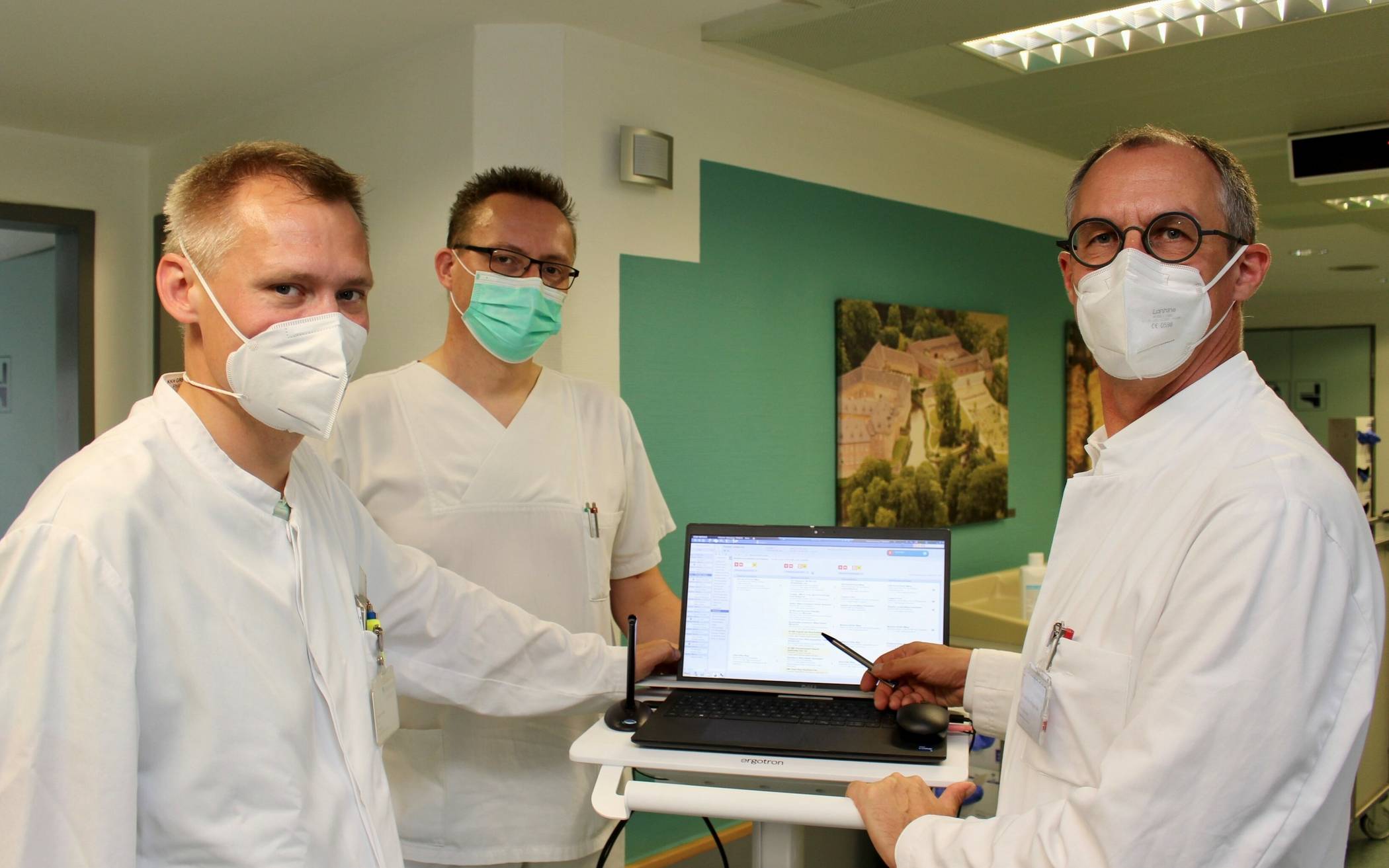 Geriatrie-Chefarzt Dr. Oliver Franz (rechts) gemeinsam mit Oberarzt Philipp Lechner (links) und Stationsleiter Bernd Heinemann (Mitte) bei der Visite auf der Geriatrischen Station – ab sofort mit Laptop anstatt mit Papierakte.  