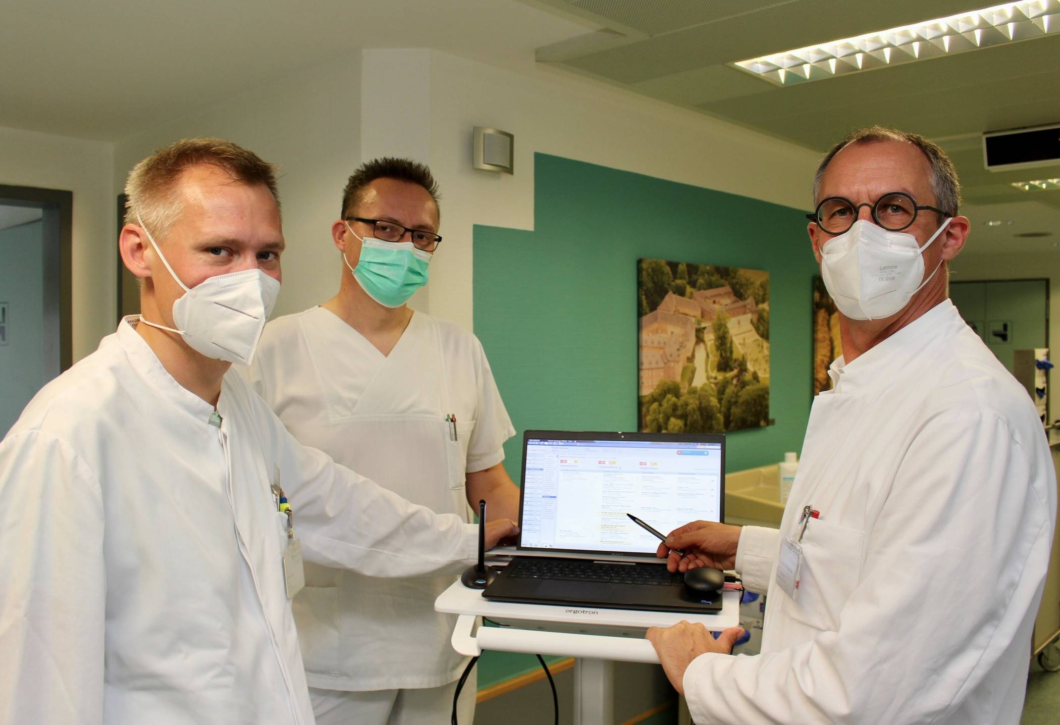 Geriatrie-Chefarzt Dr. Oliver Franz (rechts) gemeinsam mit Oberarzt Philipp Lechner (links) und Stationsleiter Bernd Heinemann (Mitte) bei der Visite auf der Geriatrischen Station – ab sofort mit Laptop anstatt mit Papierakte.  
