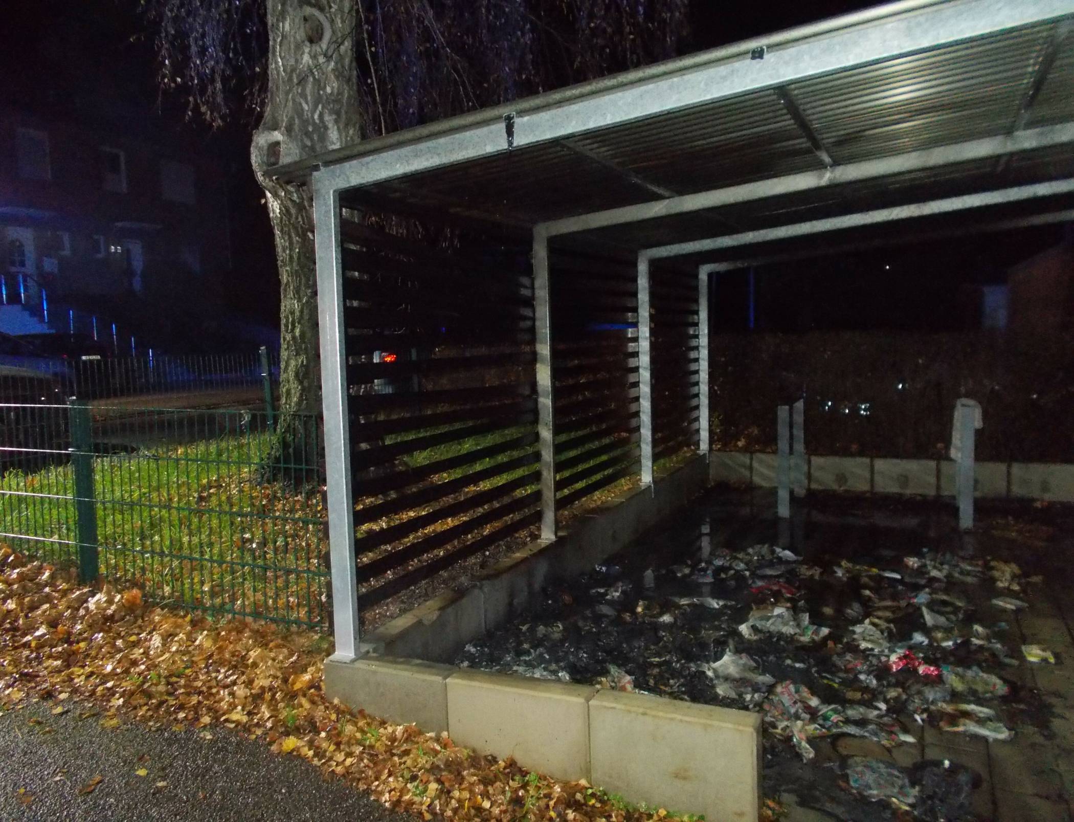  Abgebrannte Tonne unter Carport. 