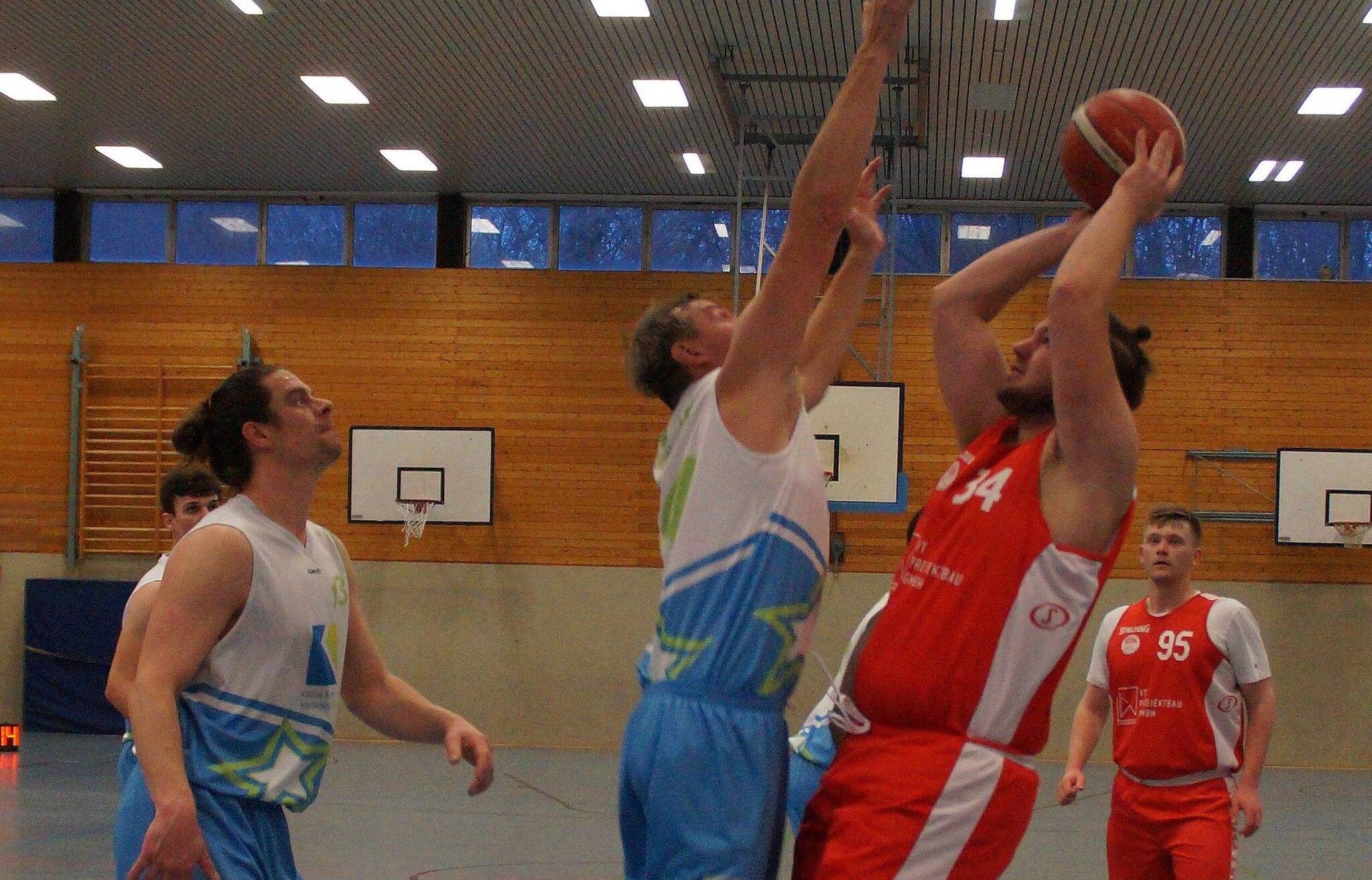 Niklas John (rechts, rotes Trikot, Nummer 34) von den Scorpions beim Versuch, gegen die großgewachsenen Norfer zum Korberfolg zu kommen. Ganz rechts im Hintergrund mit der Nummer 95 sein Mitspieler Nouel Schmidt.  