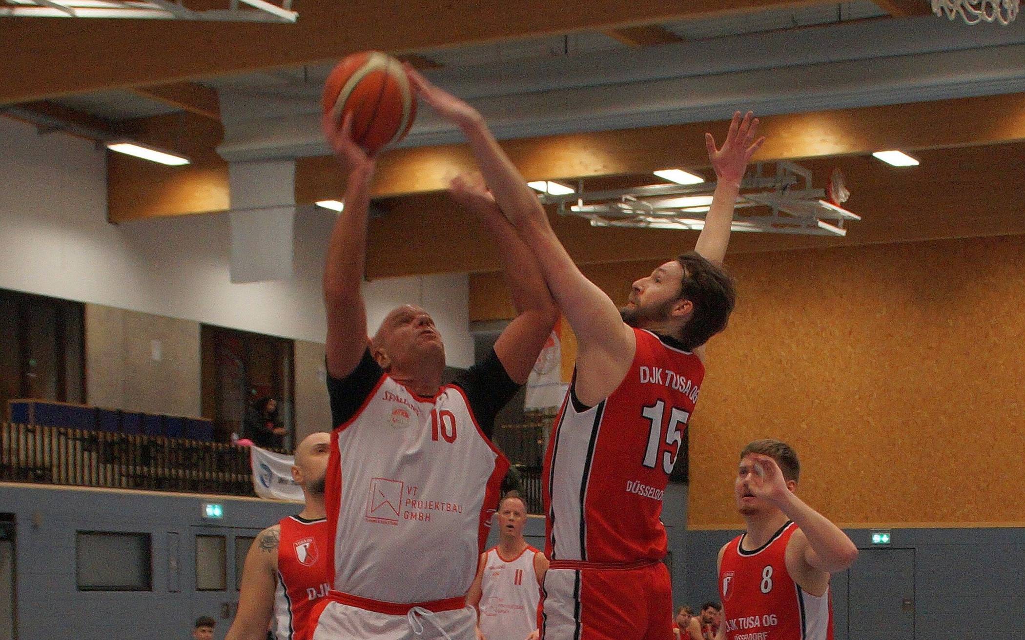  Scorpions-Kapitän Björn Pütz (links, weißes Trikot, Nummer 10) beim Korbversuch gegen seinen früheren Teamkollegen Jan Kopshoff (Nummer 15), der nun mit der TuSA nach Gierath zurückkehrte.  