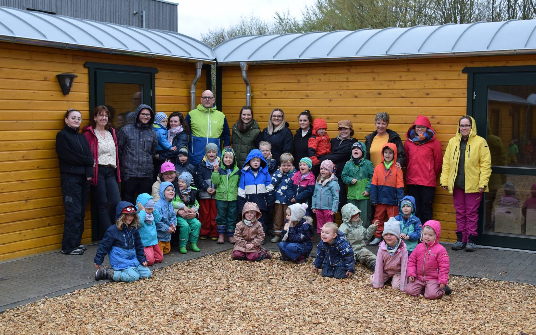 Die Kinder des Waldkindergartens freuen sich gemeinsam mit ihren Erzieherinnen und Erziehern sowie Jugendamtsleiter Carsten Esser über die neuen „Wichtelwagen“.