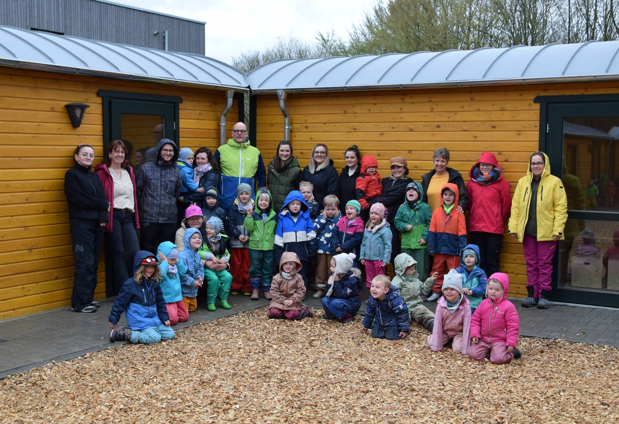 Die Kinder des Waldkindergartens freuen sich gemeinsam mit ihren Erzieherinnen und Erziehern sowie Jugendamtsleiter Carsten Esser über die neuen „Wichtelwagen“.