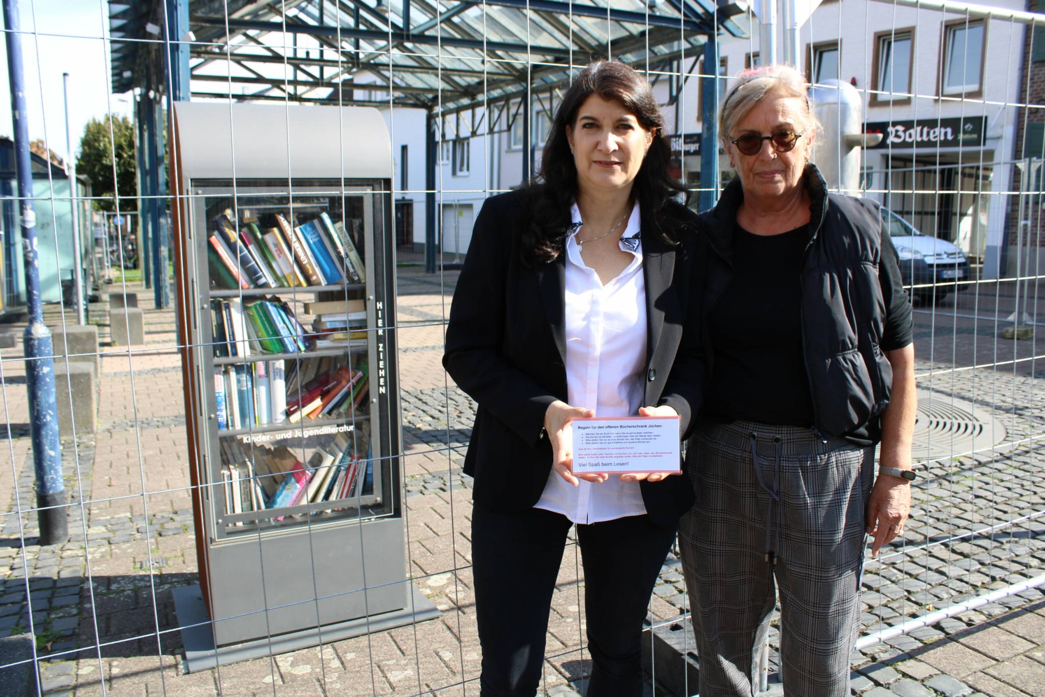 Sandra Lohr (l.) und Waltraud Hilgers kümmern sich mit weiteren Paten um die Bücherschränke. Auf einem kleinen Hinweisschild sind nun ein paar Regeln zur Nutzung der Bücherschränke zu finden.