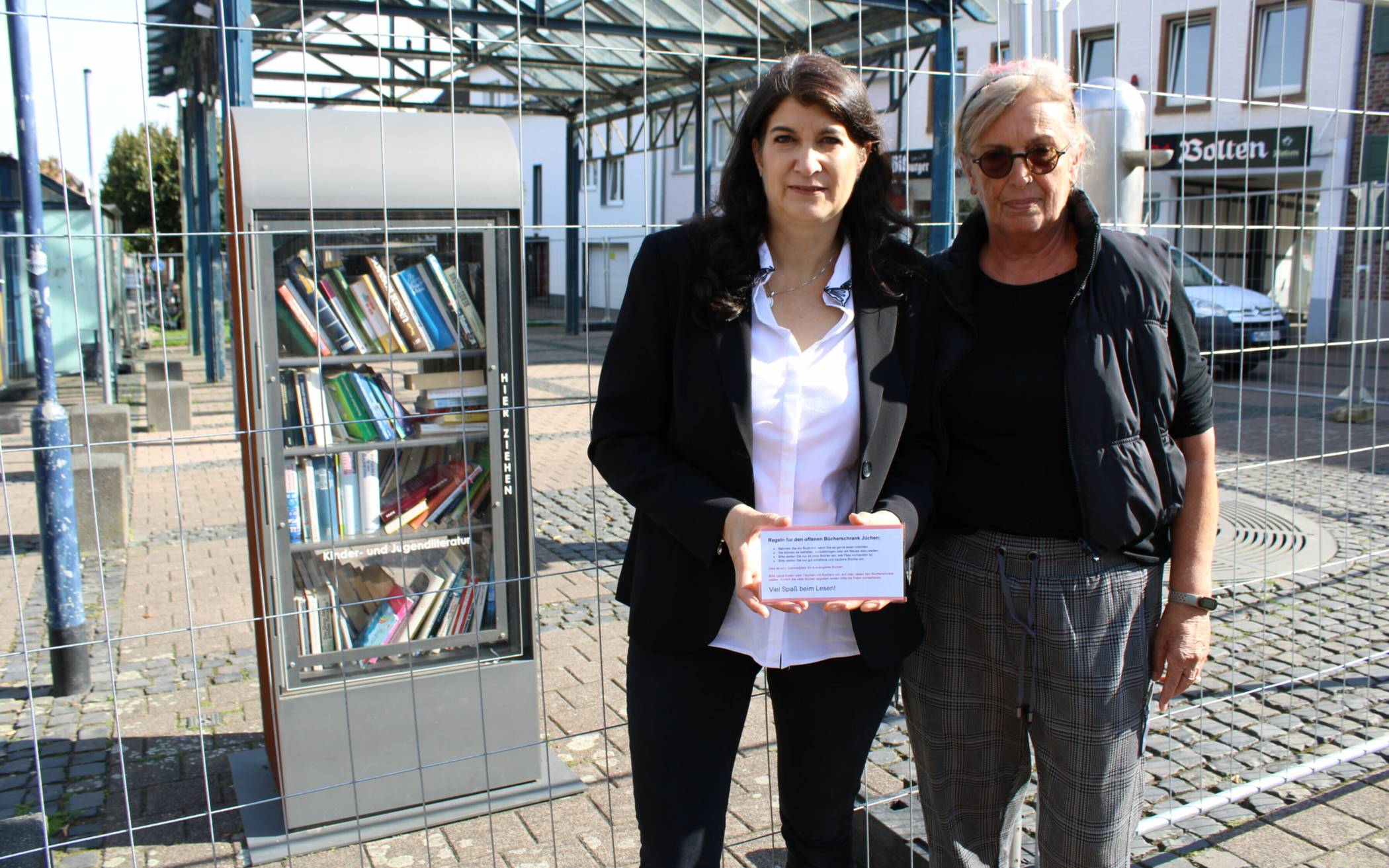 Sandra Lohr (l.) und Waltraud Hilgers kümmern sich mit weiteren Paten um die Bücherschränke. Auf einem kleinen Hinweisschild sind nun ein paar Regeln zur Nutzung der Bücherschränke zu finden.