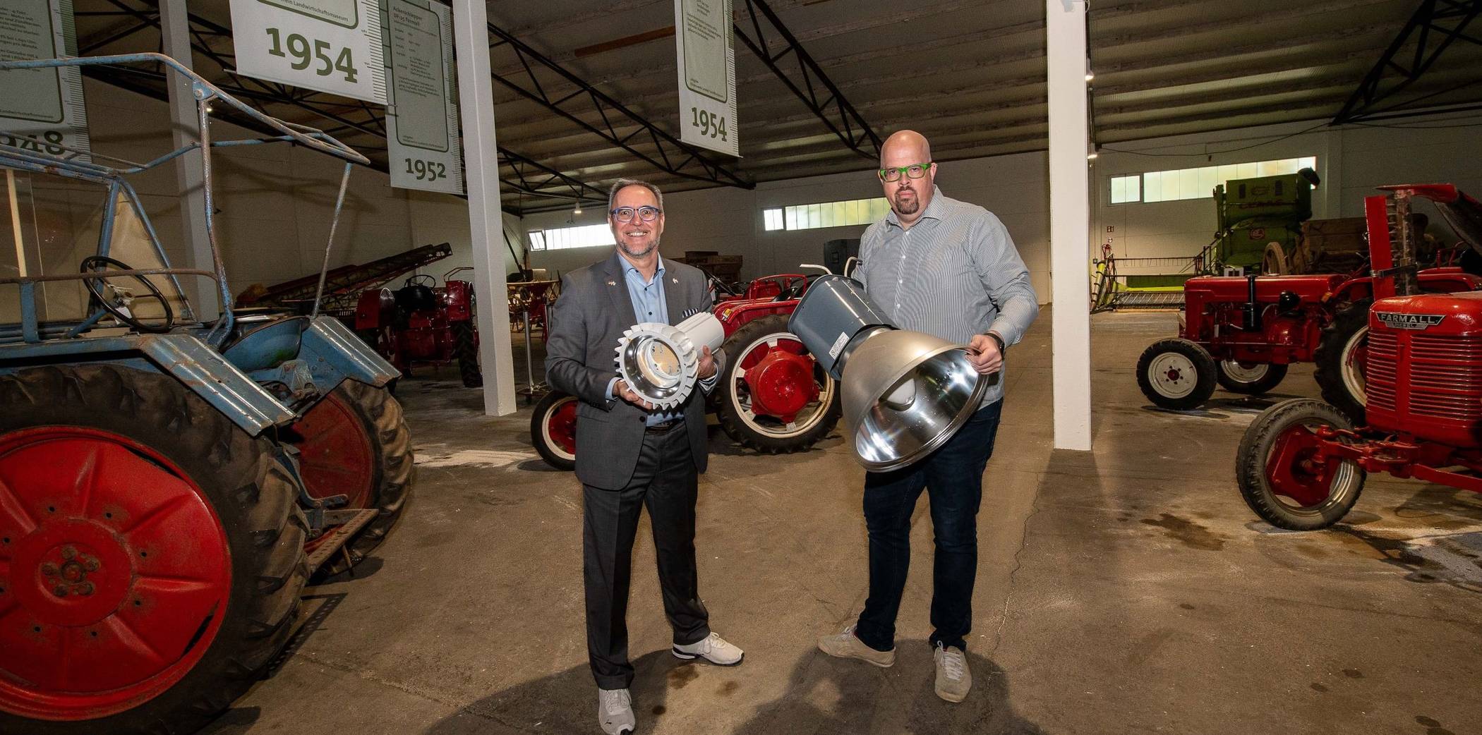 Wandel im Landwirtschaftsmuseum: ein neuer Leuchtstrahler in Händen von Baudezernent Harald Vieten (links) und das ältere, demontierte Vorgängermodell, das Jens Kotterba zeigt.