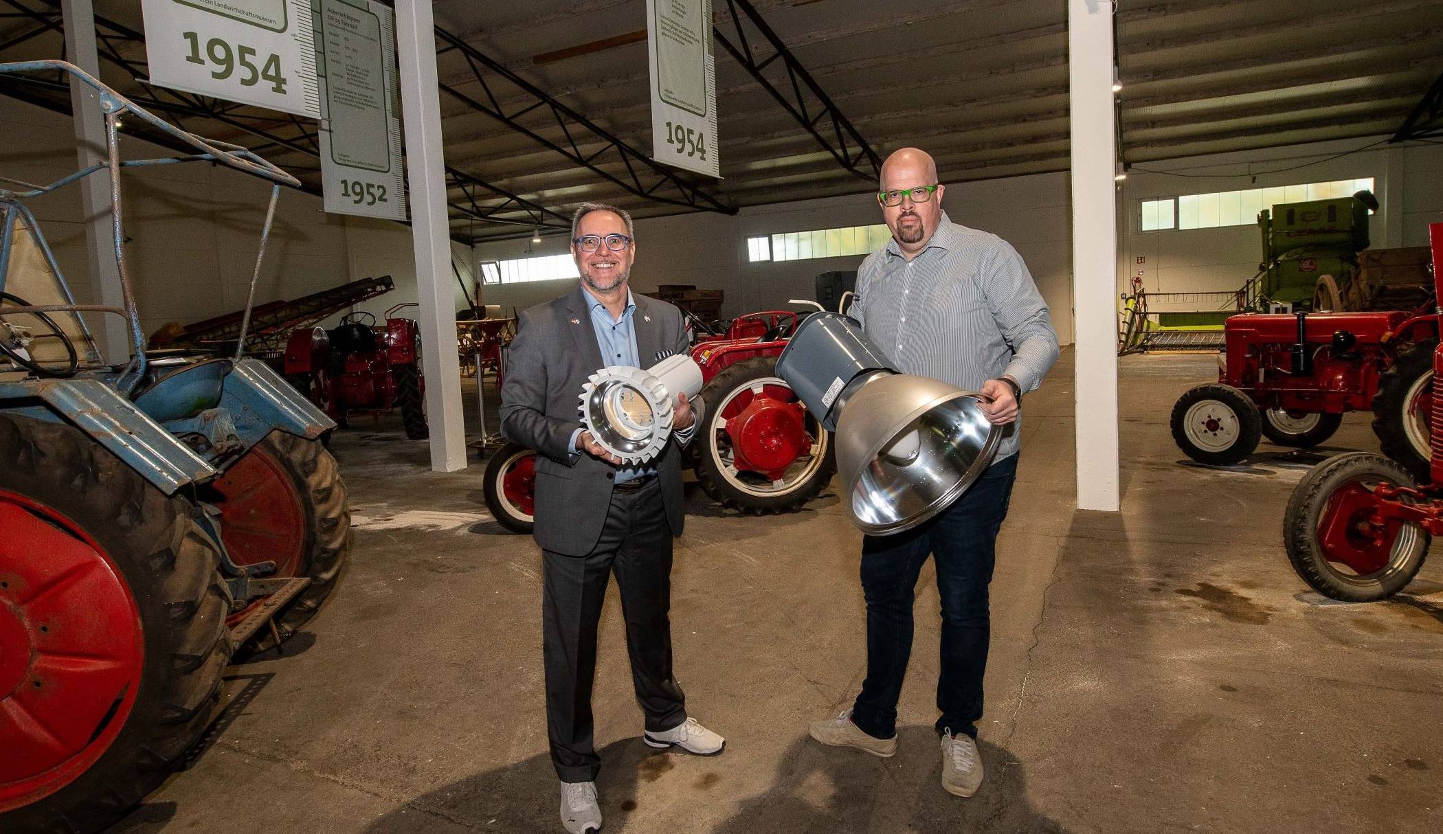 Wandel im Landwirtschaftsmuseum: ein neuer Leuchtstrahler in Händen von Baudezernent Harald Vieten (links) und das ältere, demontierte Vorgängermodell, das Jens Kotterba zeigt.