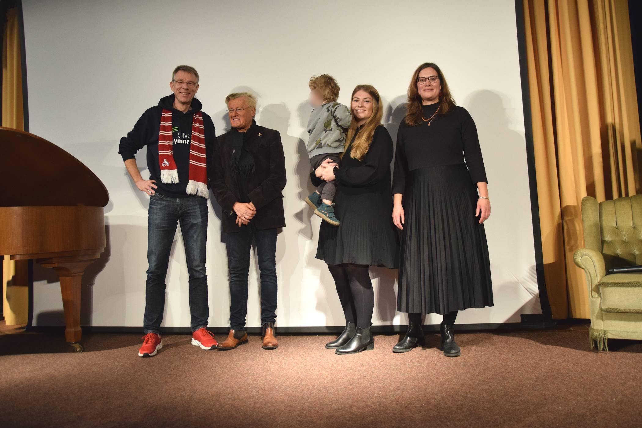 Oliver Großmann (stellvertretender Schulleiter), Michael Trippel (Stadionsprecher 1. FC Köln), Lena Schäfer und Kathrin Lay (beide Lehrerinnen und Organisatorinnen der ,lit.SILVER’) bei der Abschlussveranstaltung im Gymnasium.  