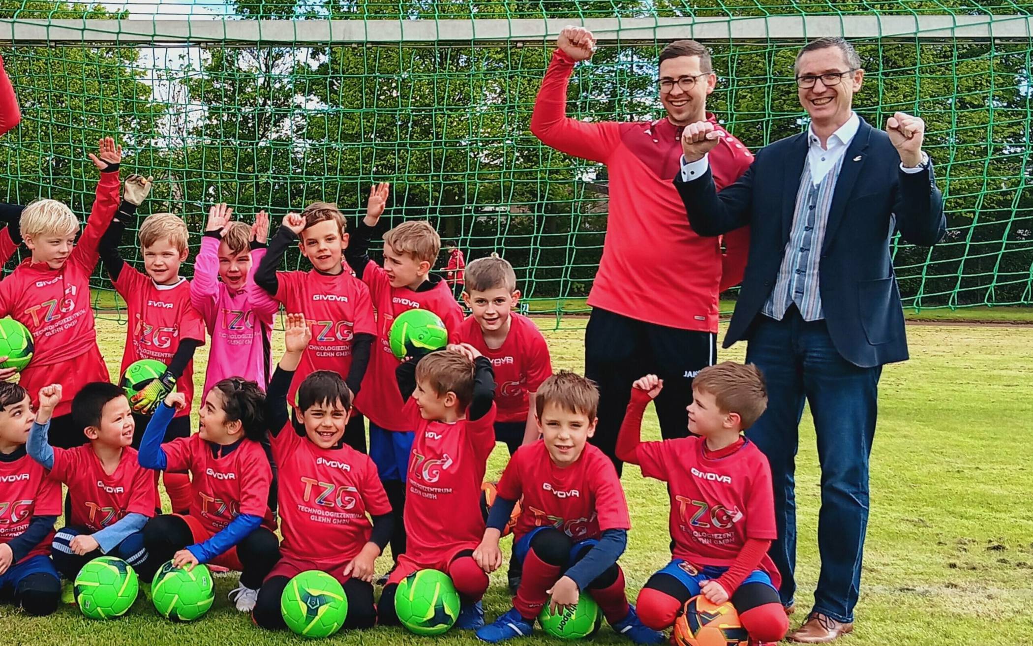 Geschäftsführer Raimund Franzen (rechts / „Das Technologiezentrum Glehn fördert gerne den Sport. Wir sind stolz, Bestandteil dieses Events zu sein.“) übte mit Spielern und Trainern schon einmal das Jubeln. Dabei wurde deutlich, dass die Harmonie zwischen Mannschaft und Sponsor auf Anhieb sehr groß war. Jetzt kann die „Erft-Kurier-Bambini-EM“ am 8. Juni auf der Sportanlage in Neuenhausen kommen. Die Reuschenberger Kicker sind schon heute bestens eingestellt.