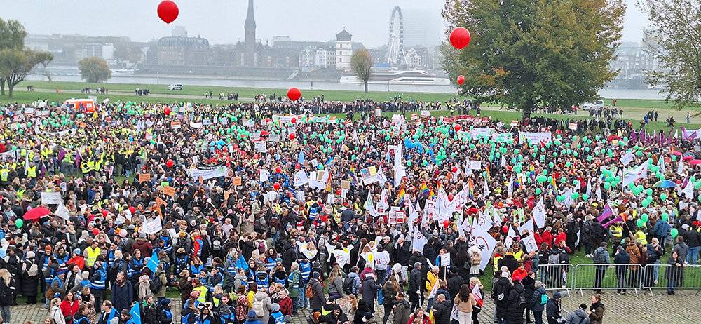  Die Oberkasseler Rheinwiese ist fast voll: Von der Rheinkniebrücke aus ist die große Anzahl der Protestler aus den Freien Wohlfahrtsverbänden gut erkennbar. 