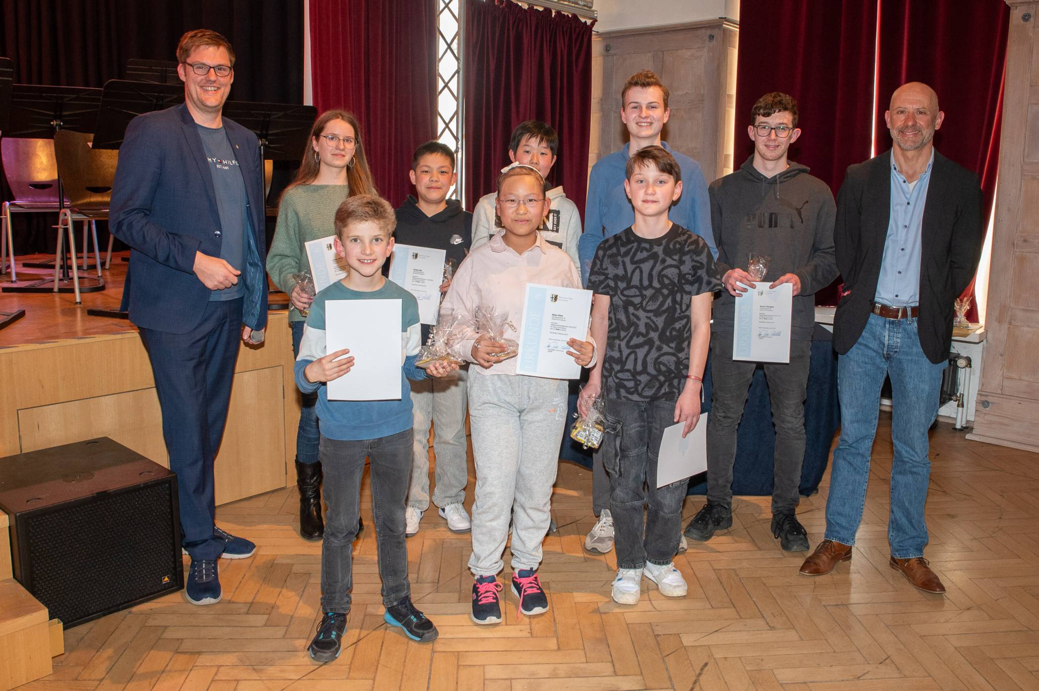 Kreisschuldezernent Sebastian Johnen (l.) und Stefan Holl (r.), Schulleiter des Marie-Curie-Gymnasiums, mit den Erstplatzierten des Mathematik-Wettbewerbs. 