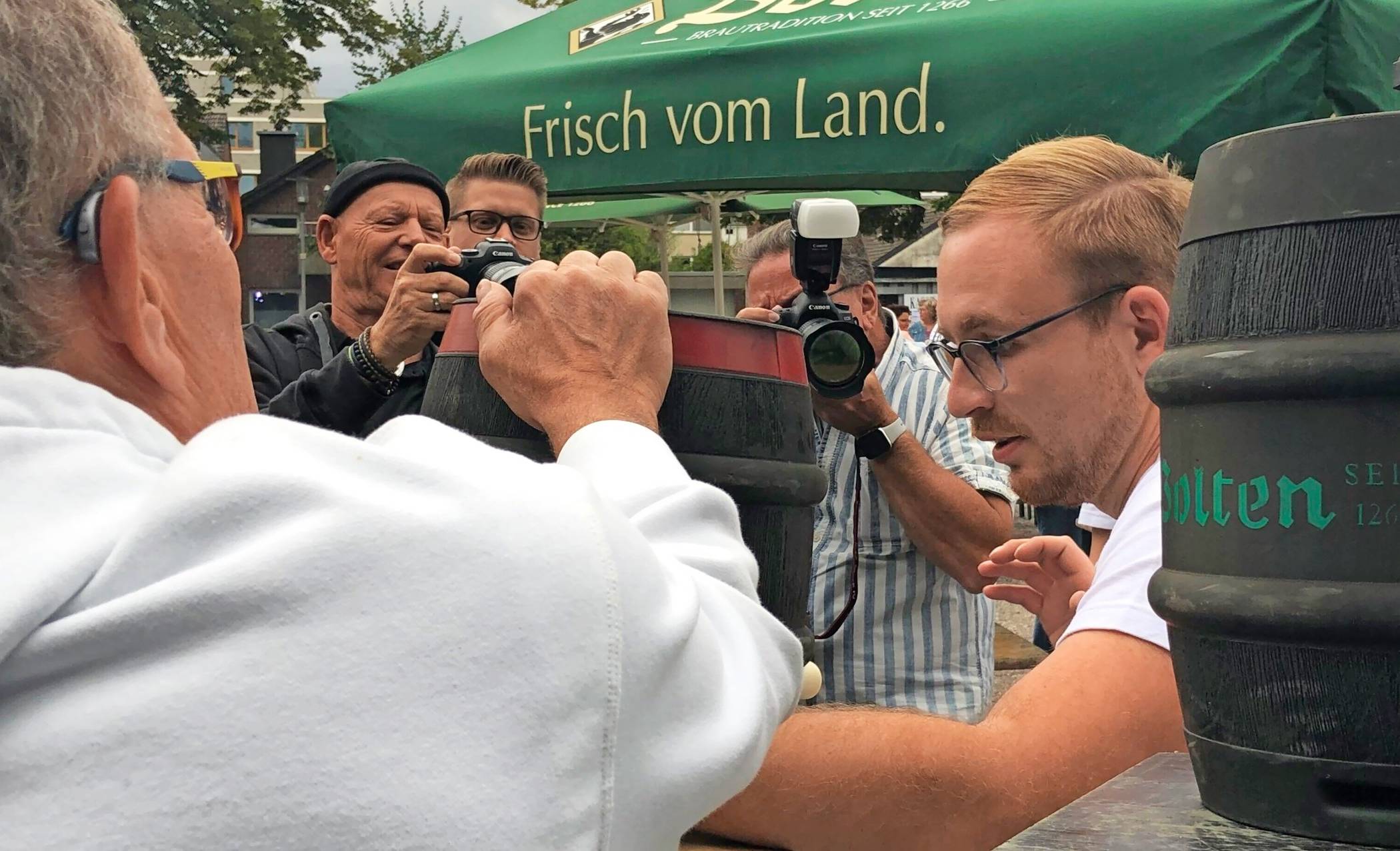 Der König legt, assistiert von Barthel Velder, Hand an: Er versucht, den Zapfhahn mit der bloßen Hand einzuschlagen. Das gelingt allerdings nicht.  