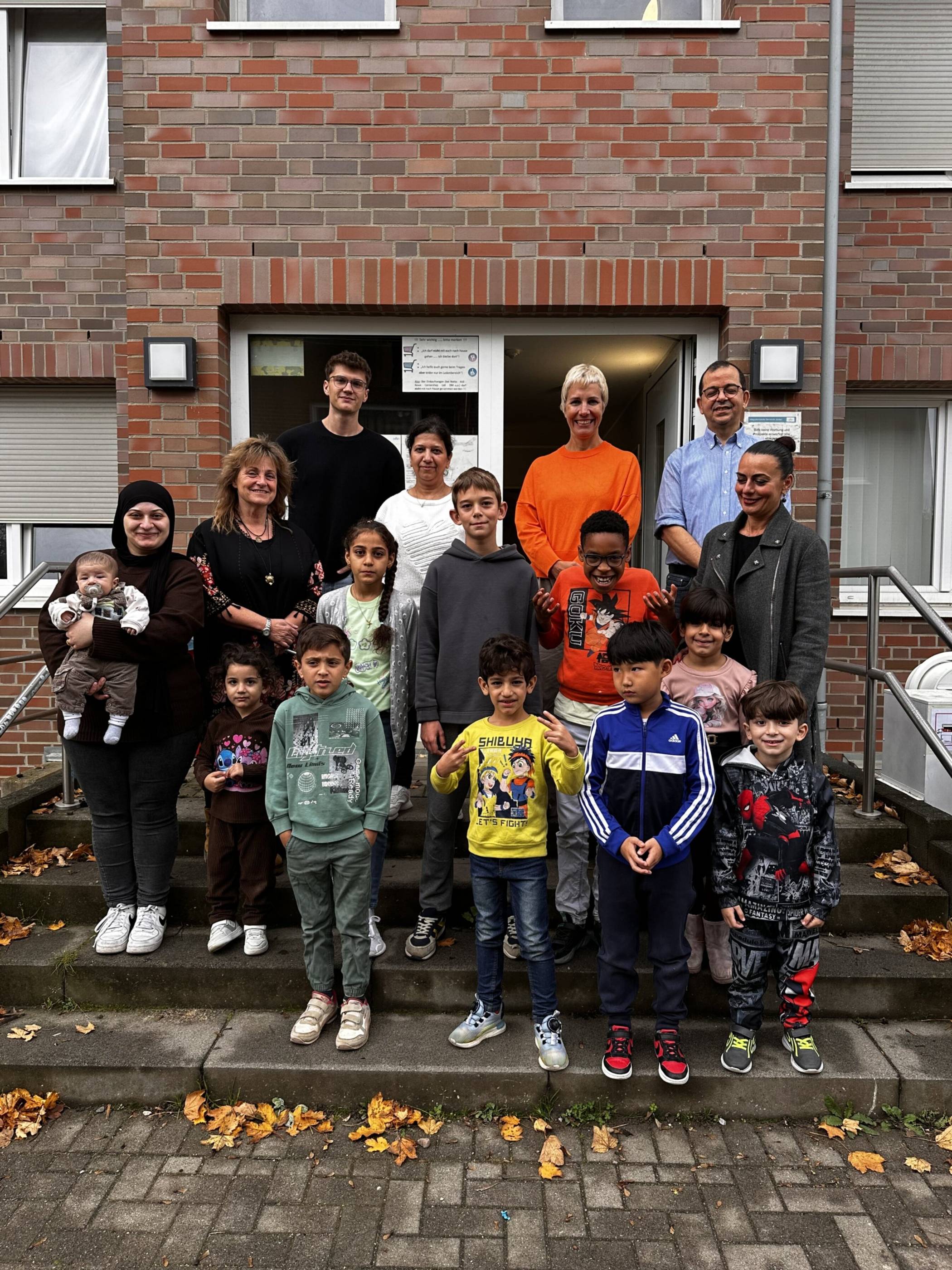 Ute Schwieren von der Integrationsstelle Stadt Jüchen, Bulgadarian Begler Enoshi vom kin-top Förderzentrum, Vincent Wolf von der Integrationsstelle Stadt Jüchen, Annette Gratz, Sozialdezernentin Stadt Jüchen, Nour Kacimi vom kin-top Förderzentrum (obere Reihe von links) und Olena Kuchynska (kin-top Förderzentrum) (rechts) mit Teilnehmern der Ferienfreizeit.