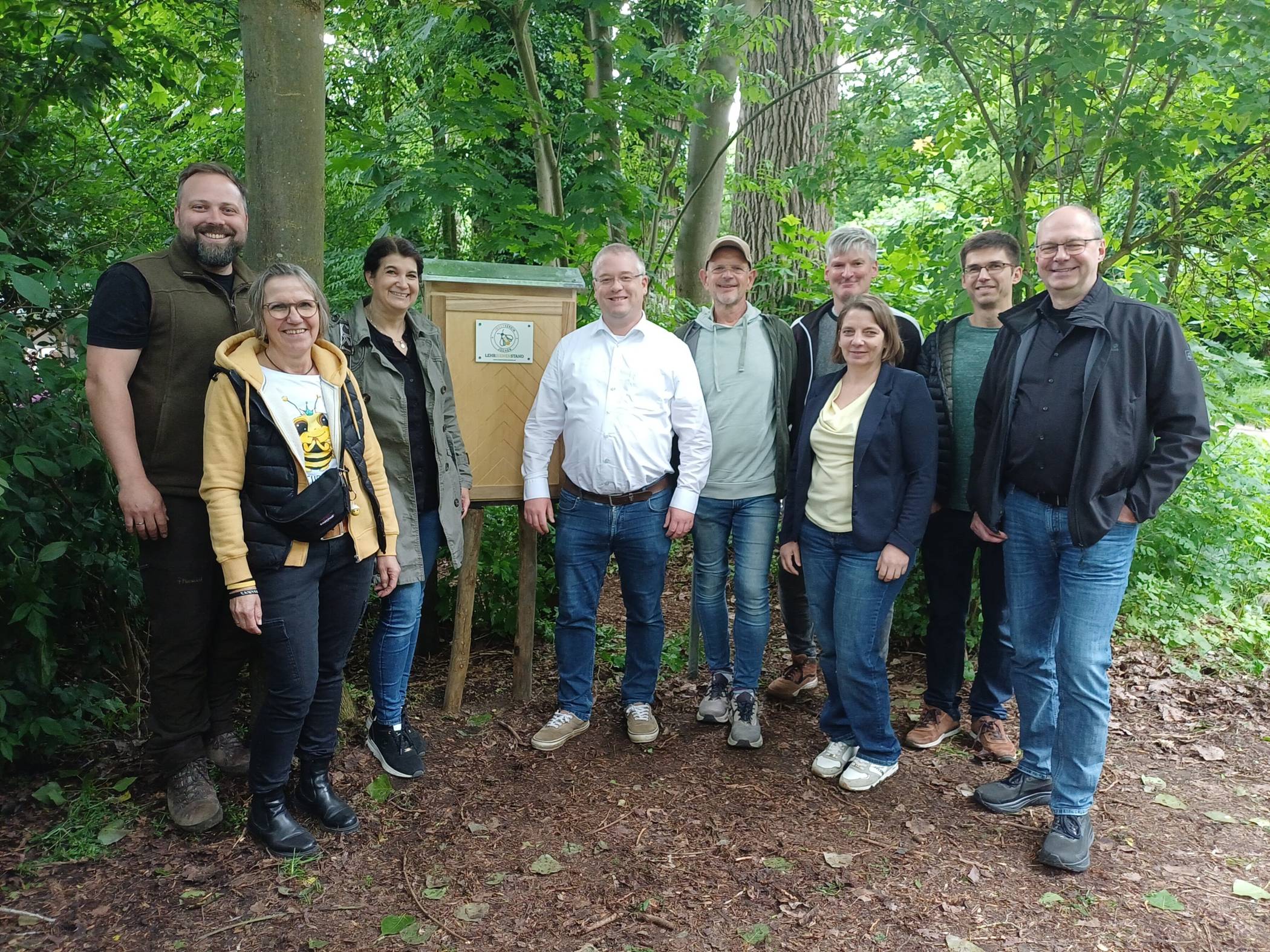  Vorsitzender Rene Bamberg (links) und Geschäftsführerin Andrea vom Dorp (Zweite von linls) mit Mitgliedern des Imkervereins Jüchen sowie der stellvertretenden Landrätin Sandra Lohr (Dritte von links) und Bürgermeister Philipp Sieben (Vierter von links) vor dem neuen Bienenschaukasten, der pünktlich zur Jubiläumsfeier fertig wurde.  
