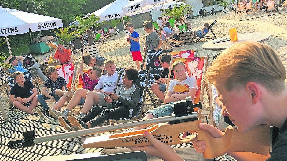  Zum „chilligen“ Königsschützen trafen sich Edelknaben und Jugendschützen auf „Evita-Beach“. Genau das Richtige für die „Coolen“ im Regiment des Bürger-Schützen-Vereines aus der Innenstadt. Der spätere Edelknabenkönig Jan Pesch hätte das Event dabei beinache verpasst: Denn er war auf dem Weg aus den Kurzferien von London nach Grevenbroich wahrlich im Zug stecken geblieben. Nicht im „Eurostar“, der war püntklich, nicht im ICE, der war auch pünktlich, nein ausgerechnet im Regionalzug von Köln … Als Familie Pesch mit einer großen Verspätung ankam, musste die Mutter kurzerhand dran glauben und wurde samt Gepäck auf dem Bahnhof stehen gelassen. Die beiden Männer — Vater Stephan und Sohn Jan — liefen zur Beach. Und der Junior machte alles klar. Rechts das Bild zeigt den Schützennachwuchs am „eisernen Turm“ aus ganz hohe Perspektive.  