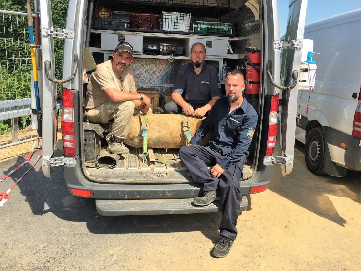  Mitarbeiter des Kampfmittelbeseitigungsdienstes unter der Leitung von Dirk Putzer (links) mit einer der entschärften Bomben. 