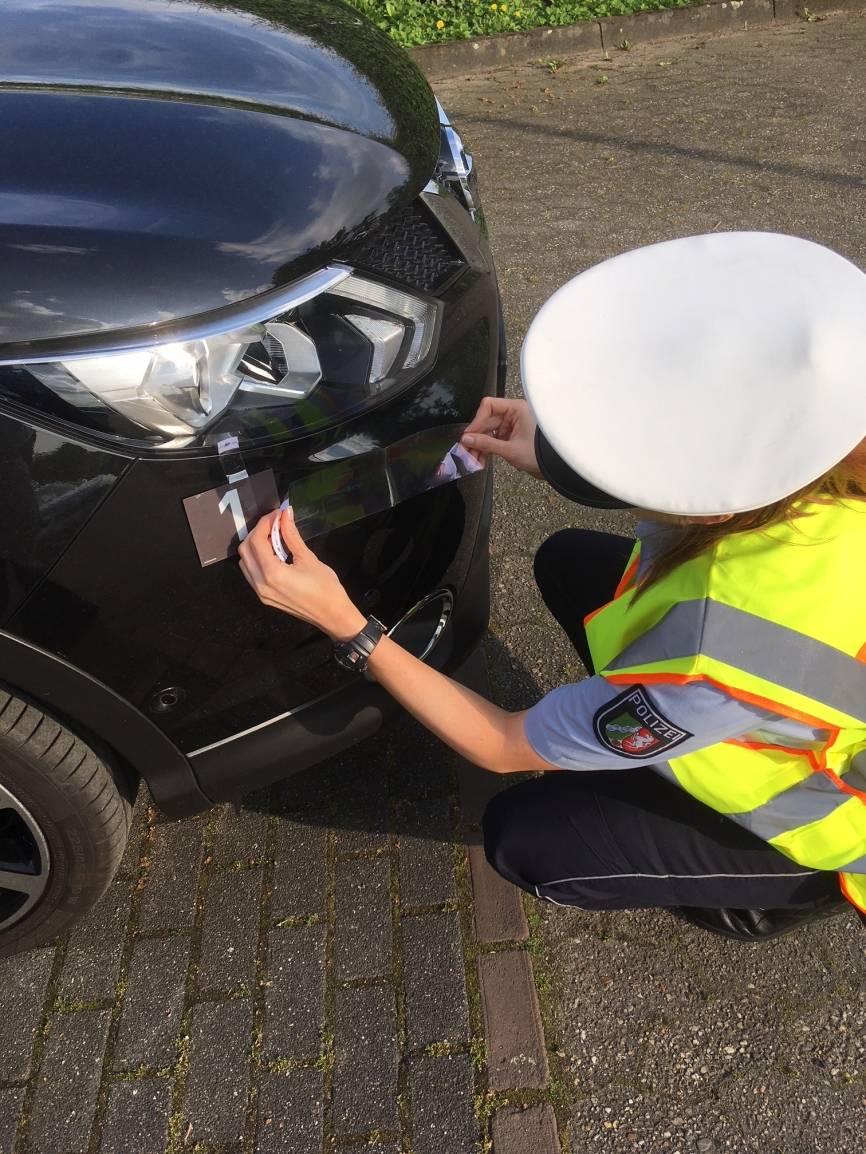  Eine Polizistin sichert Spuren am Unfallwagen, um den Verursacher zu ermitteln. Symbolbild: Polizei 