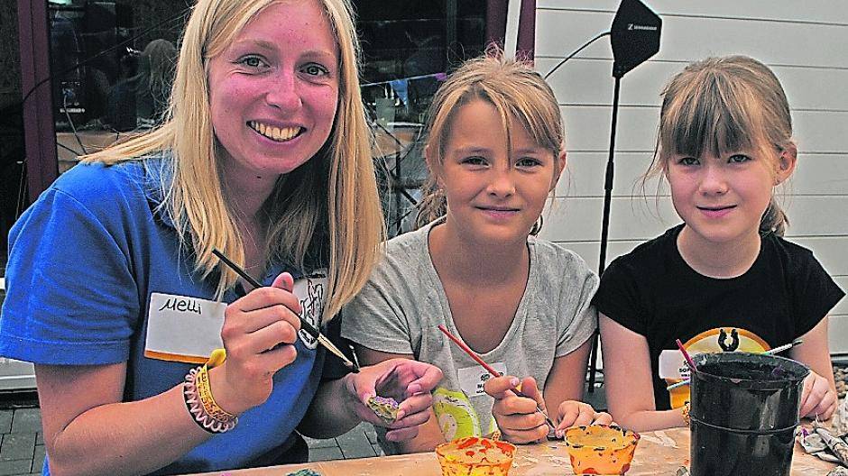  Betreuerin Melanie Winzen beim Bemalen der Kristalle (mitte). Der Thron wurde von den Kids für Bürgermeister Harald Zillikens gebaut (links) und die Kinder beim Feuermachen. 