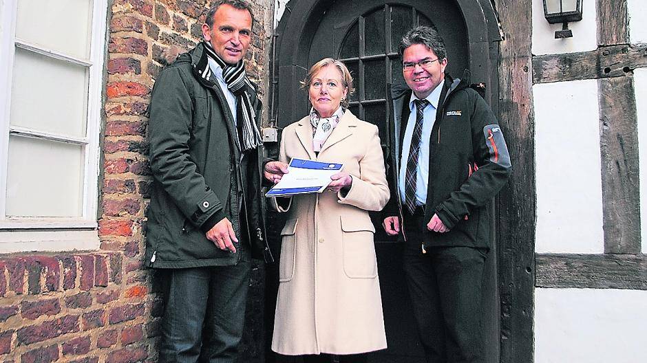  Jens Spanjer, Vorstand der Stiftung Schloss Dyck, Elisabeth Janssen von der Deutschen Stiftung Denkmalschutz und Bodo Kemper von West-Lotto vor dem Fachwerkgebäude. 