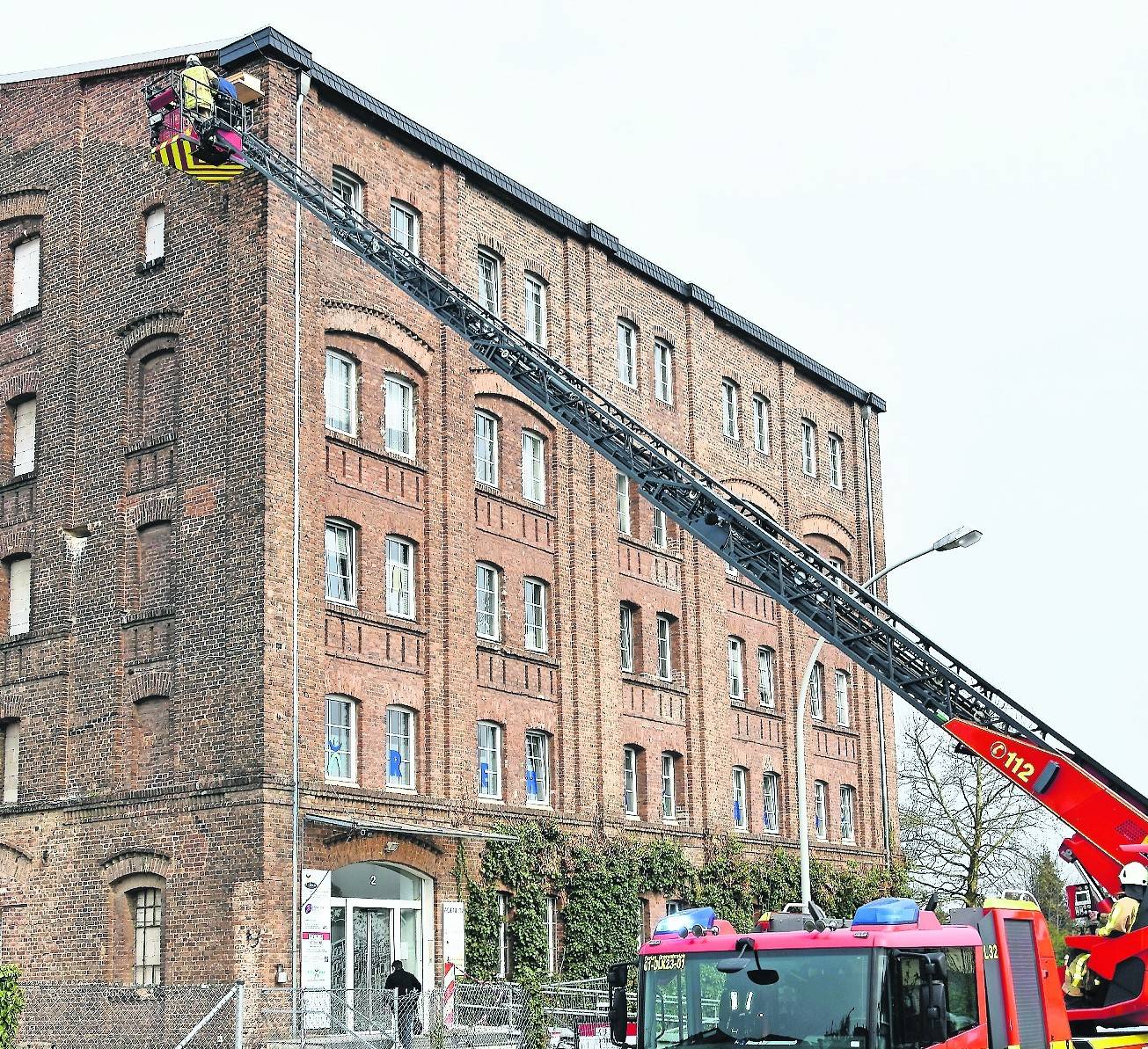 Zwei Feuerwehrmänner arbeiteten in luftiger Höhe, um den falkengängigen Nistkasten am „Quäker“-Gebäude zu befestigen. <![CDATA[]]>Umweltbeauftragter Norbert Wolf.