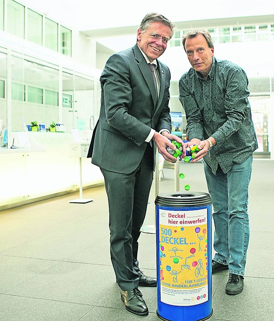   Landrat Hans-Jürgen Petrauschke und Dirk Gerardts, Betriebsstättenleiter der Varius Werkstätten, stellen die neuen Sammelbehälter für Kunststoffdeckel in den Kreishäusern Neuss und Grevenbroich vor.  