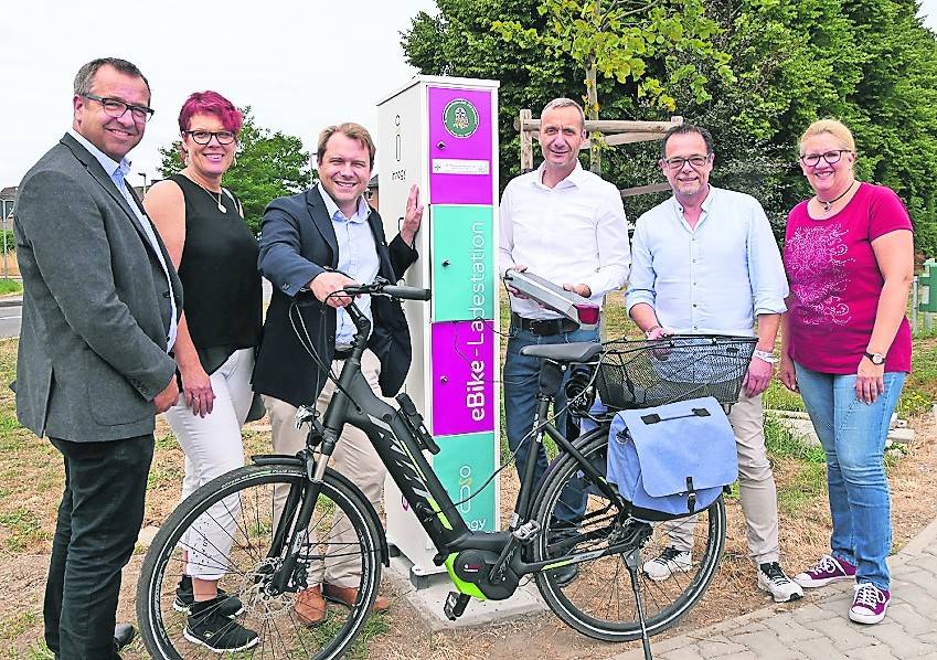  Vertreter der Stadt, der Bruderschaft und von „innogy“ sowie Bürgerinnen freuen sich über die Ladestation. 