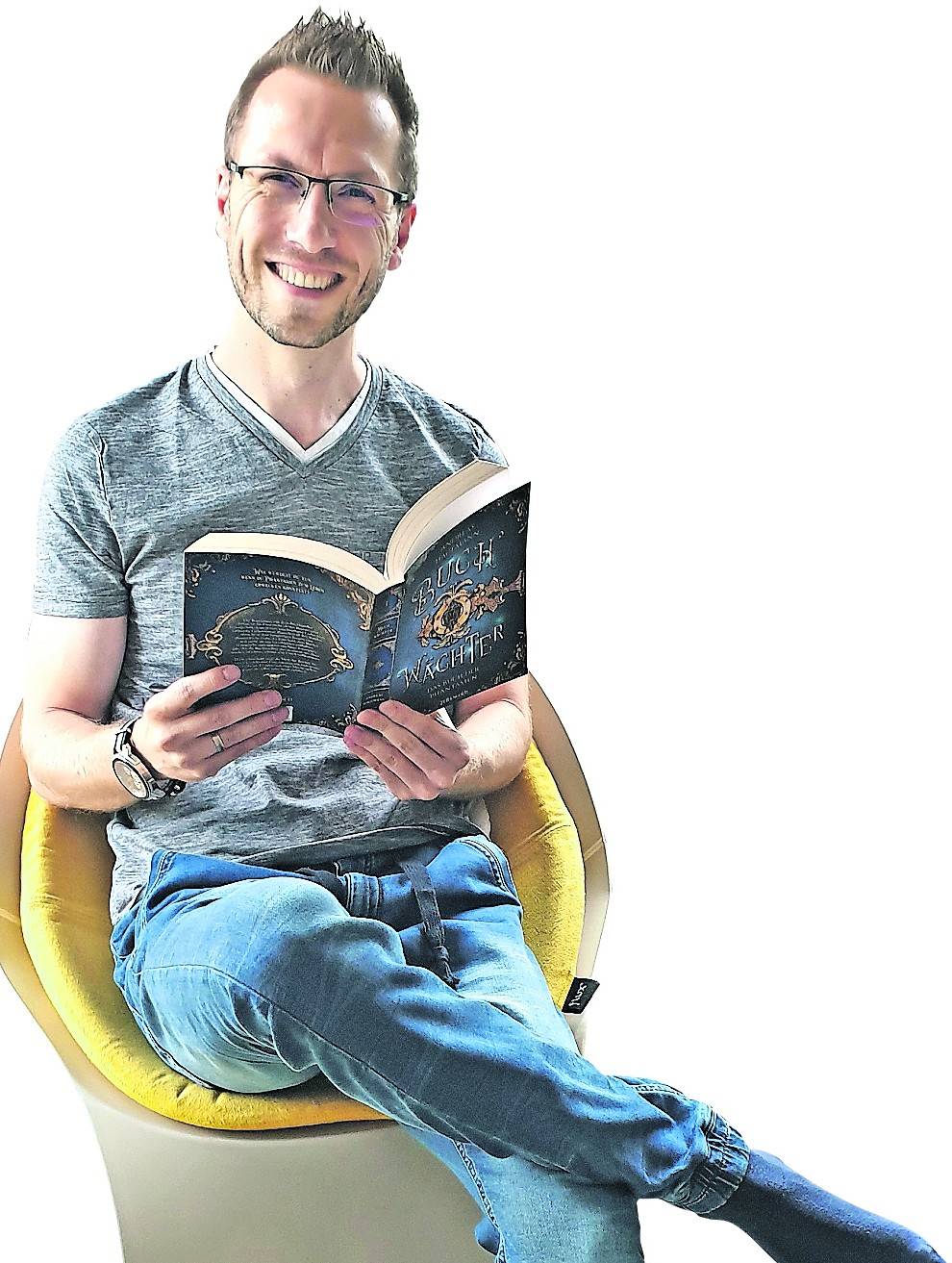 Andreas Hagemann mit seinem neuen Buch „Buch Wächter“ in seiner Lese-Ecke.