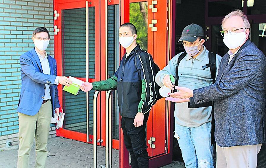  Pascal-Leiter Manfred Schauf und Schuldezernent Michael Heesch verteilen Masken an die Abiturienten.  