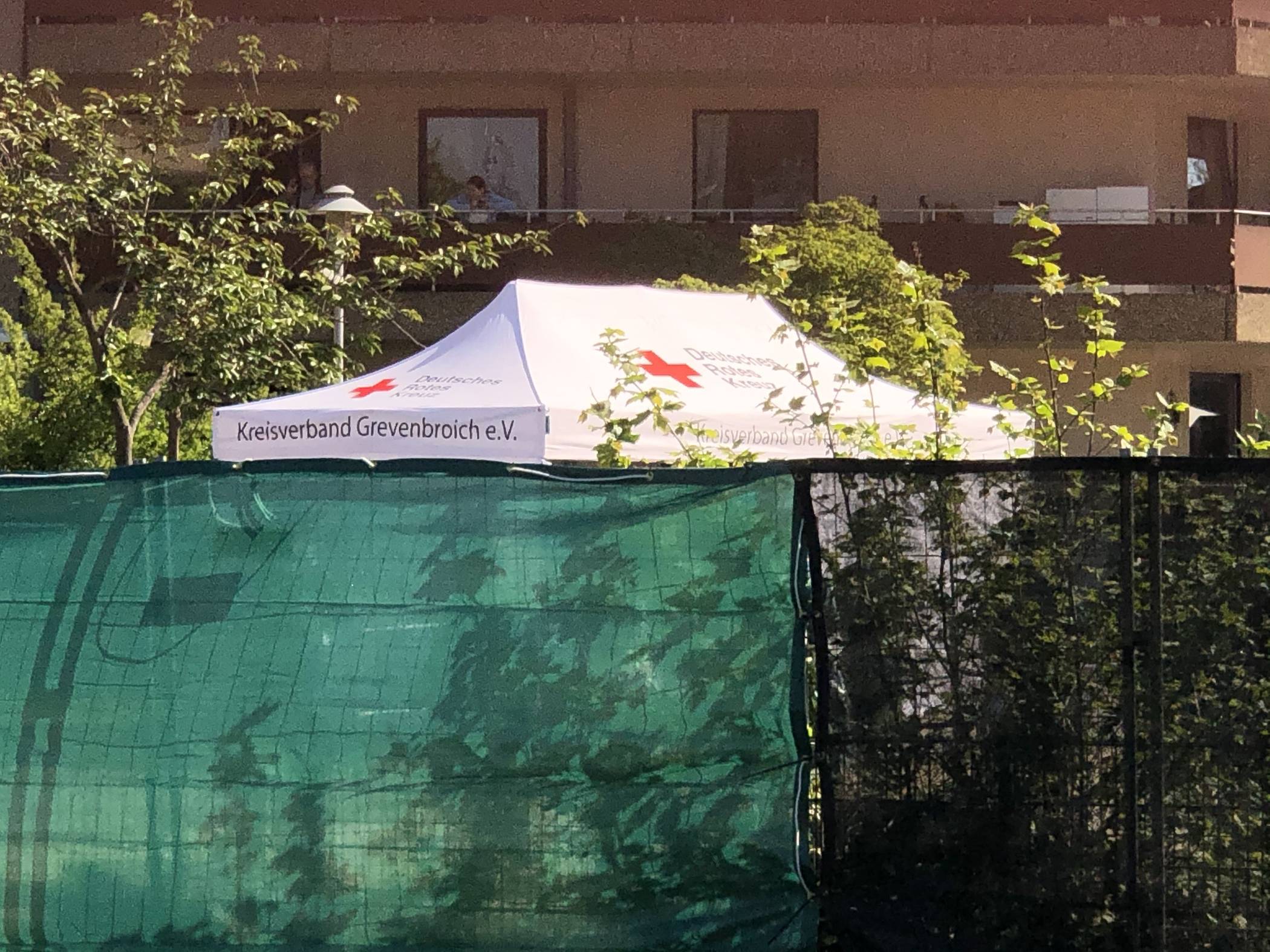  Hinter Sichtschutzzäunen werden die  Bewohner des Wabenhochhauses der Reihe nach getestet. 
