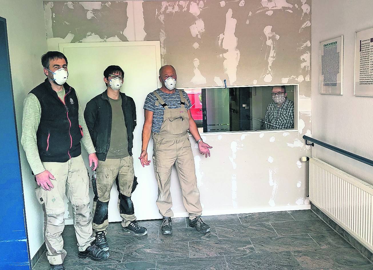   Der Feinschliff kommt in den nächsten Tagen – die Wand steht: Der neue Treffpunkt im „Haus Maria Frieden“, errichtet von Tischlermeister Alfred Bischof (Dritter von links) und seinem Team. Begeistert hinter der Scheibe (rechts): Einrichtungsleiter John Esser. 