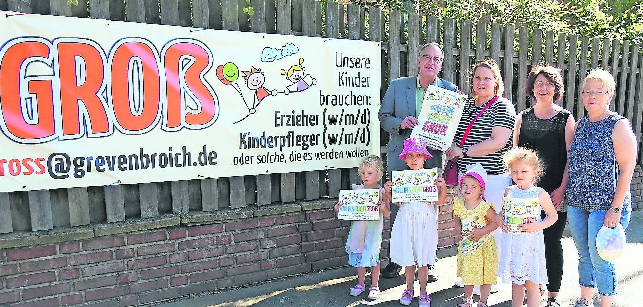 Michael Heesch, erster Beigeordneter, Fachberaterin Svetlana Schaarmann-Tröger, KiTa-Leiterin Susanne Giesen und Heidemarie Nix stellen unterstützt von Kindern aus dem Familienzentrum „Traumzauberhaus“ das erste Banner und die Kampagne vor.