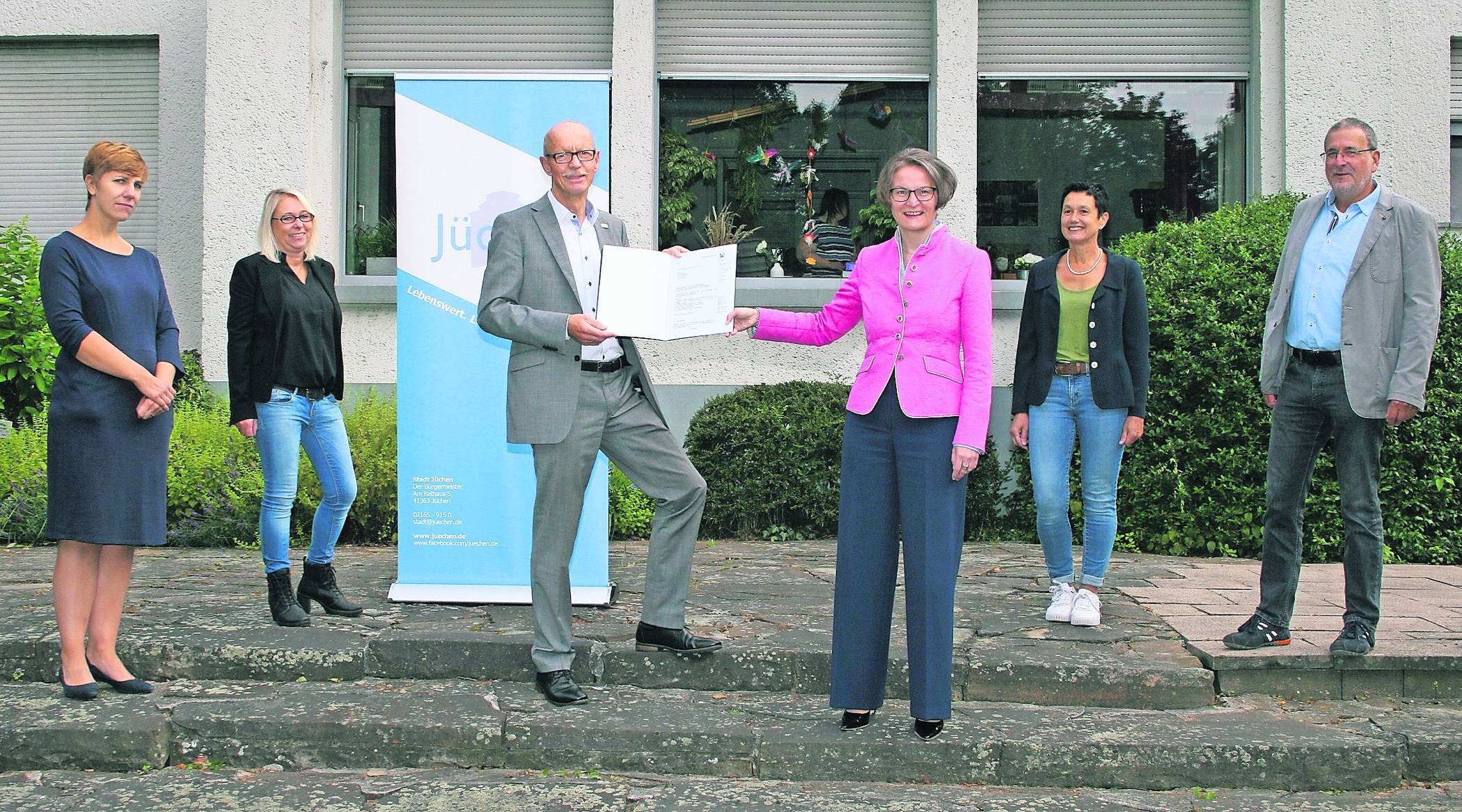 Heimatministerin Ina Scharrenbach (4.v.l.) machte in Jüchen Station und hatte gute Nachrichten für Hochneukirch im Gepäck: Die Sanierung der Terrasse an der Villa Schmölder wird bezuschusst! Bürgermeister Harald Zillikens nahm den Zuwendungsbescheid in Höhe von 32.143 Euro entgegen.  