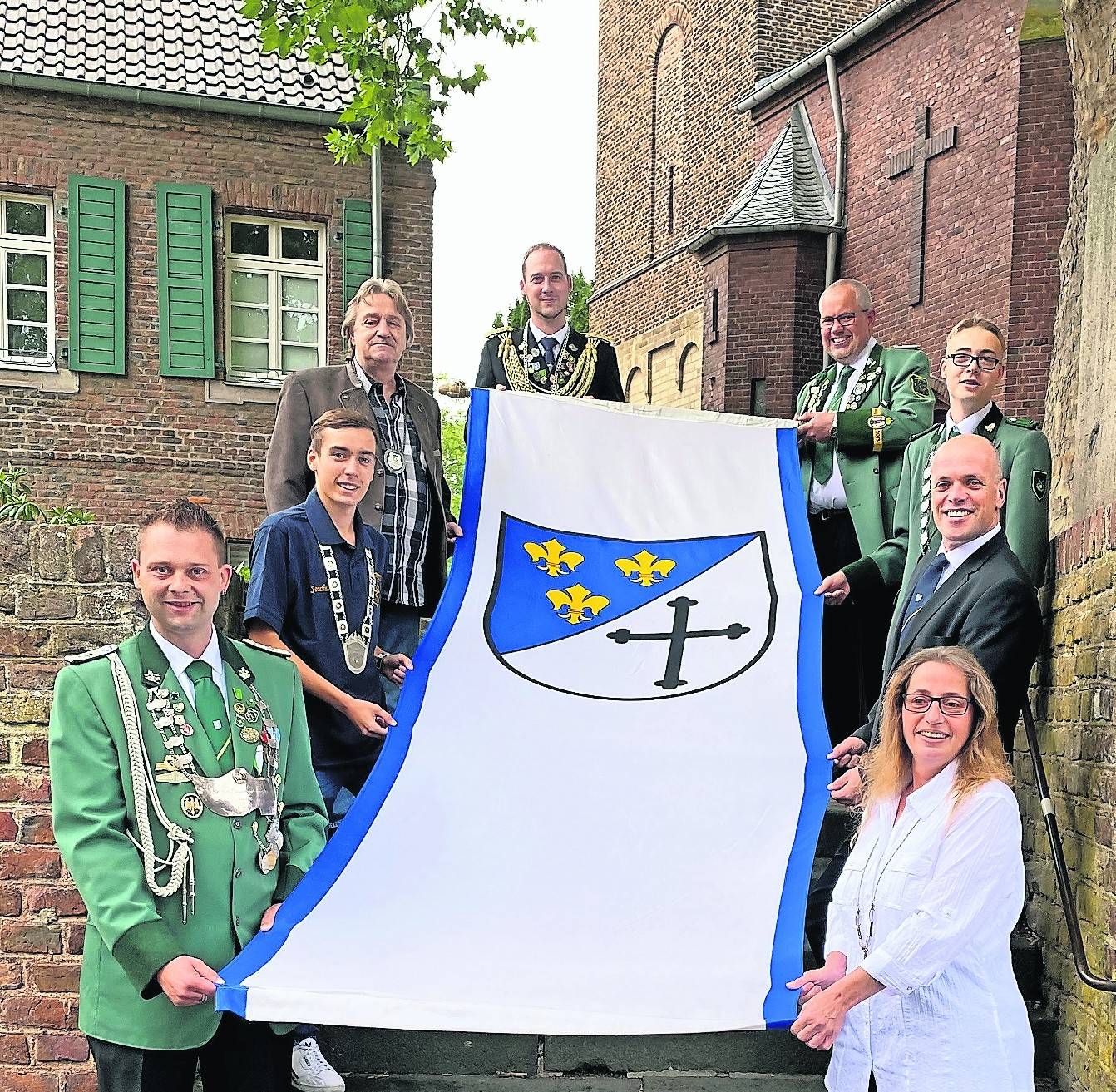 Im Bild von links Dominik Wendland, Joschua Boles, Hans-Josef Kauertz, Sebastian Büll, Oliver Beil, Adrian Hemmersbach, Bürgermeister Klaus Krützen und Claudia Gluch bei der Übergabe der Vereinsfahne an die Stadt.