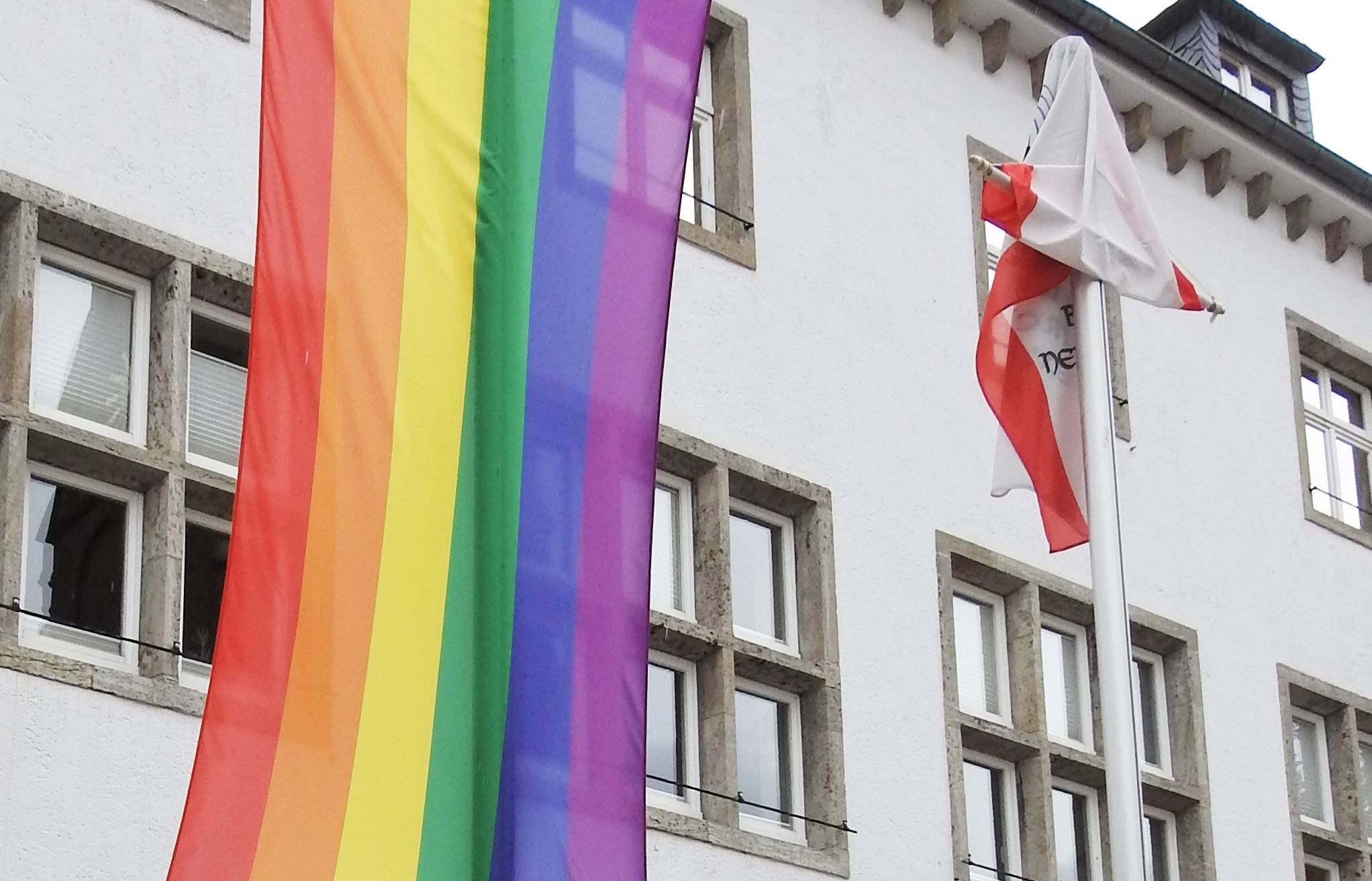  Bürgermeister Klaus Krützen vor der Regenbogen-Fahne am Grevenbroicher Rathaus. 