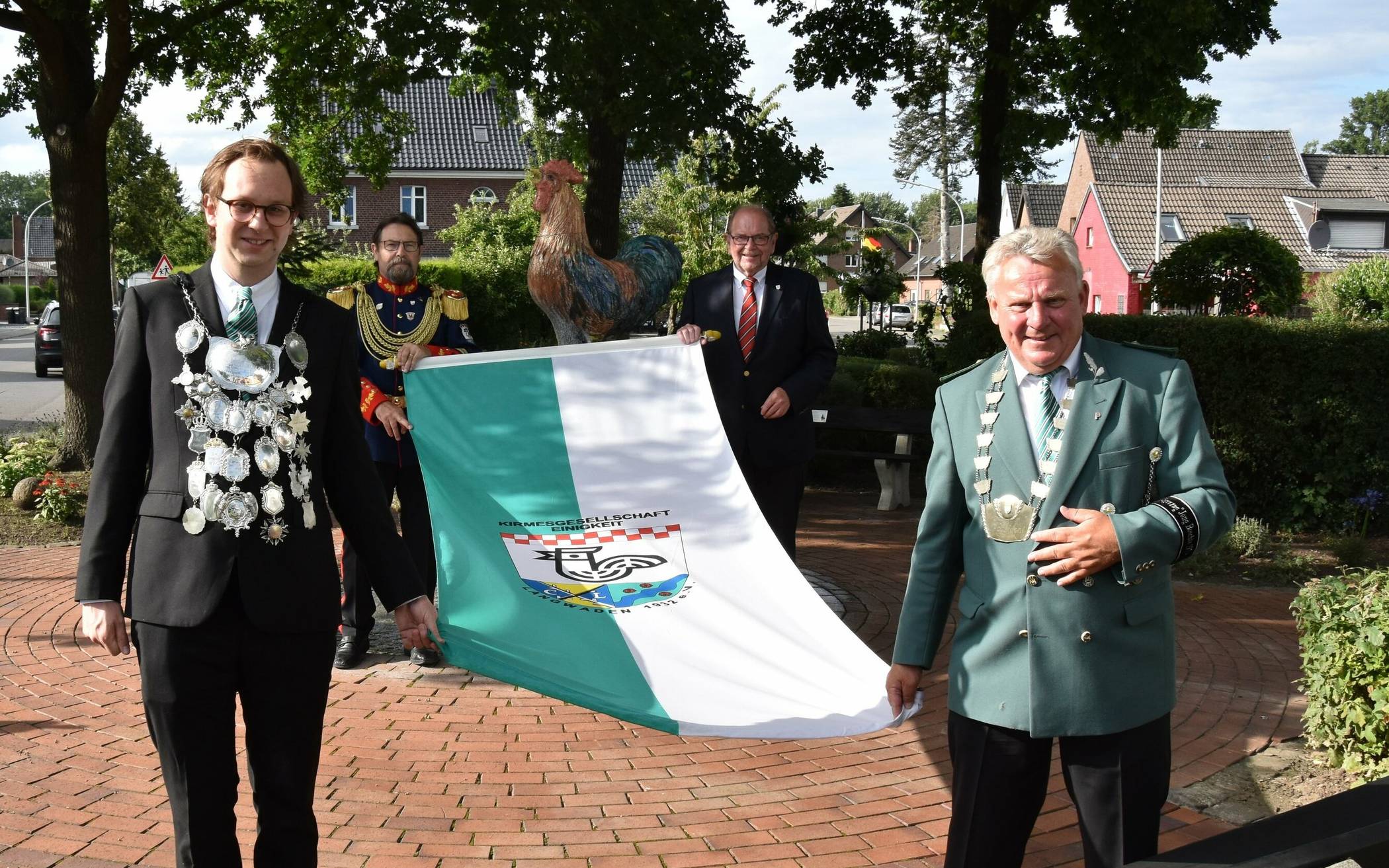  Fahnenübergabe in Langwaden. Zu sehen sind vorne Hahnenkönig Felix von Nesselrode und Präsident Heiner Hoffmann, hinten Oberst Frank Rademacher und Vize-Bürgermeister Edmund Feuster. 